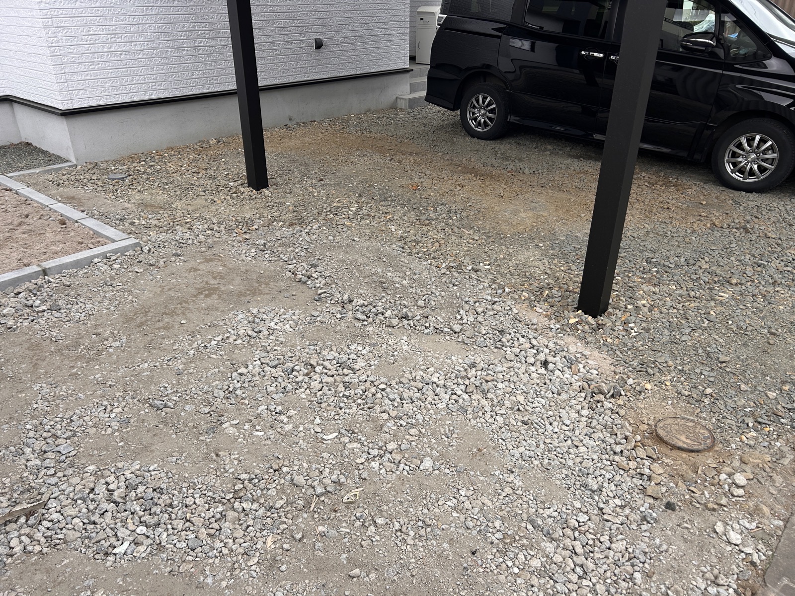 カーポート周辺の砂利敷き駐車スペース。でこぼこが目立ち、砂埃が道路に流れ出していた状態