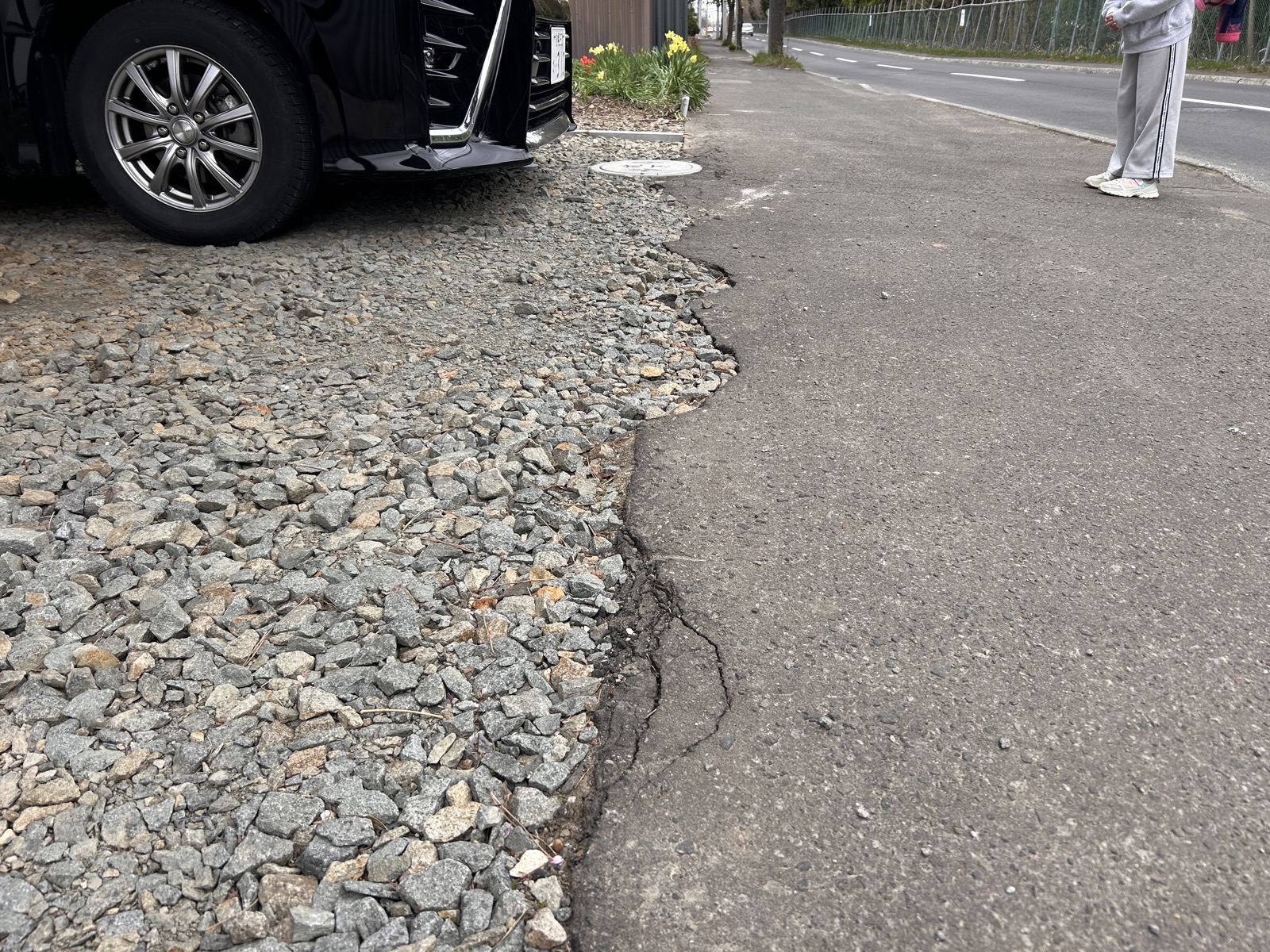 道路境界部分のアップ。既存アスファルトとの接合部に大きな亀裂と段差が生じていた