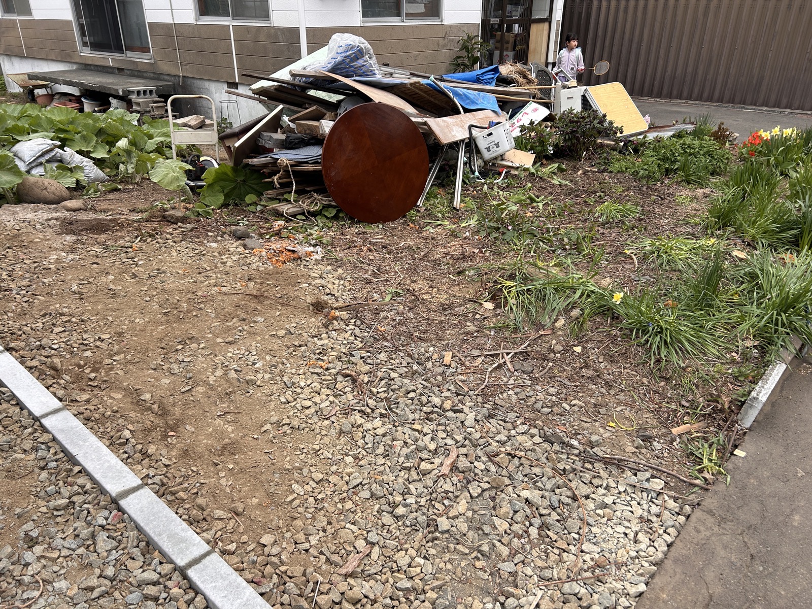 庭に山積みになった残置物。廃材・家具・家電類が長年にわたって堆積していた