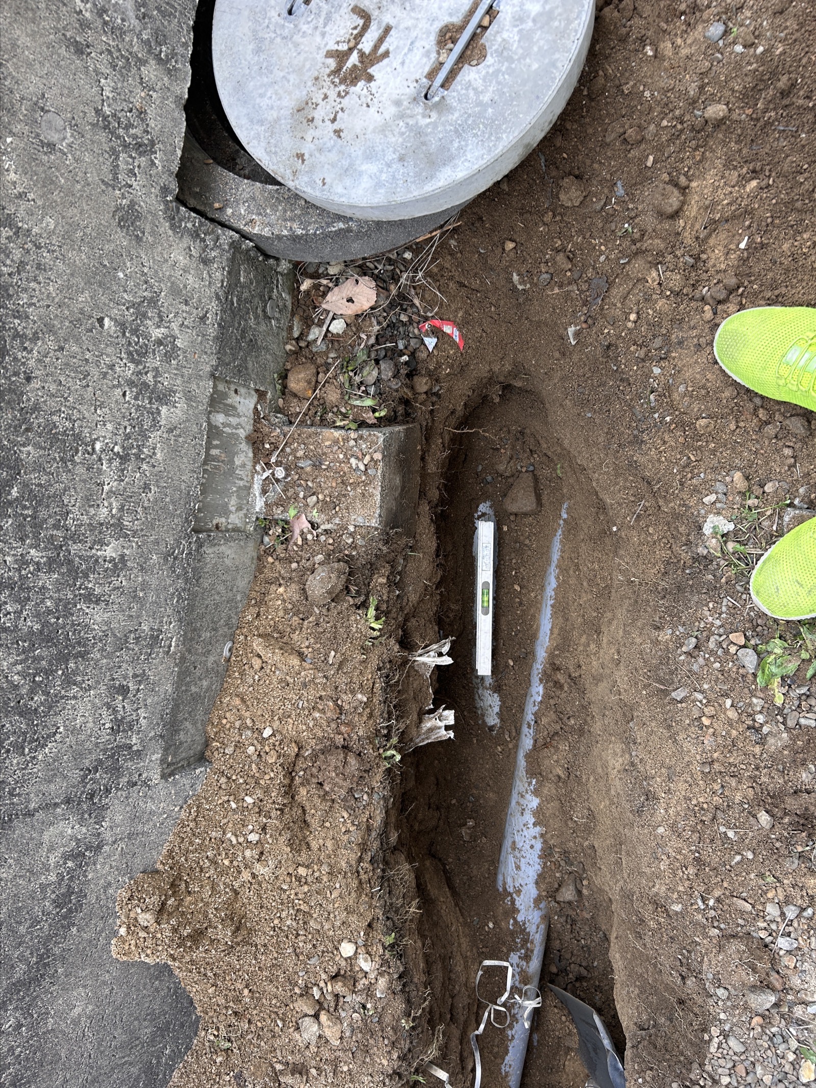 新管設置完了：適切な勾配で塩ビ管が設置され、マスへの接続も確認済み