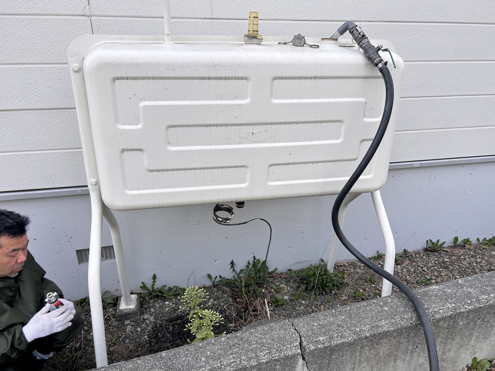 工事前：公共マス上に設置された灯油タンク。掘削の障害となるため灯油を抜いて移動が必要