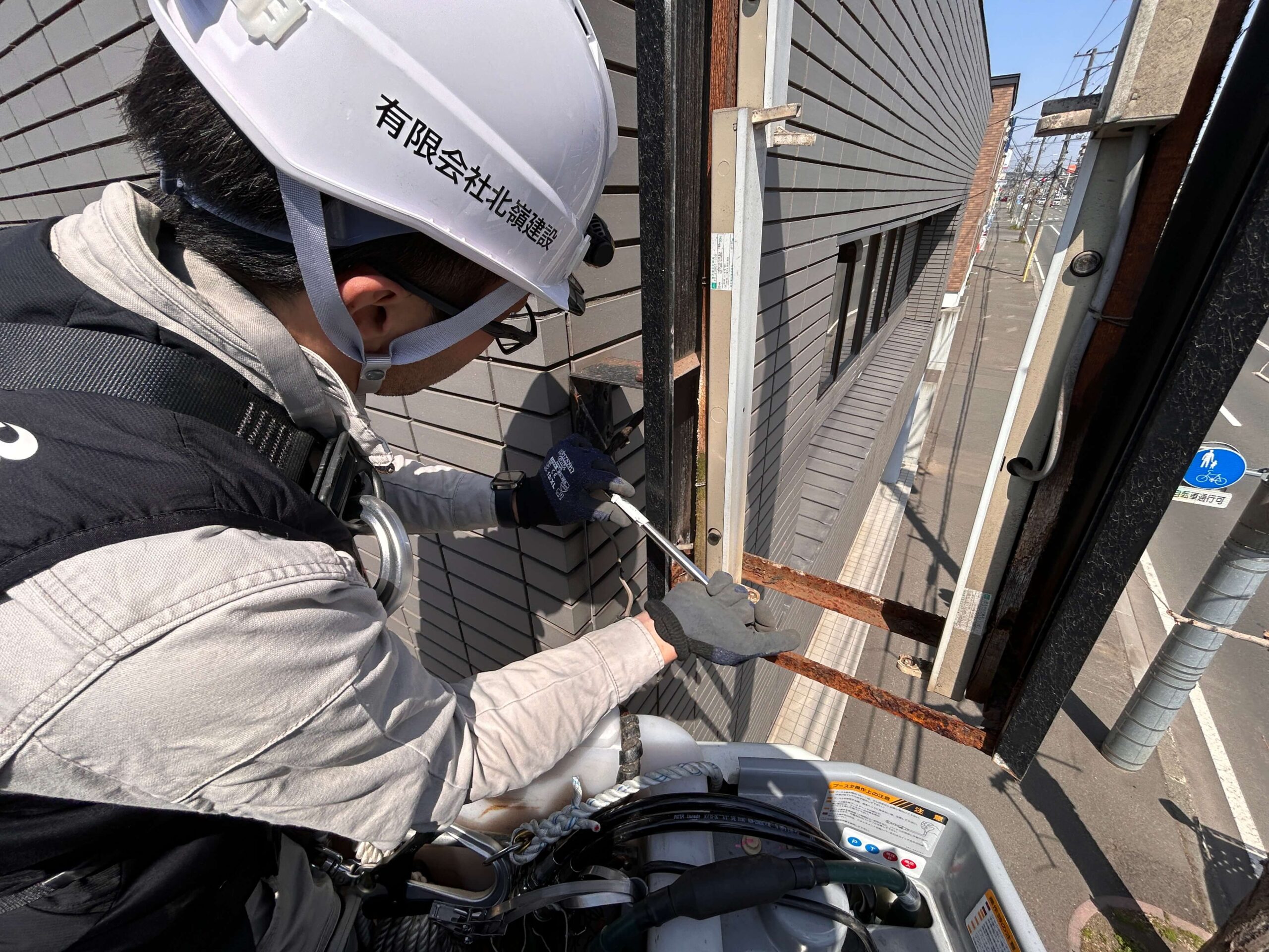 作業中（地上確認）：地上では誘導員が常に通行状況を確認。歩道を歩く通行人への声かけを続けている。