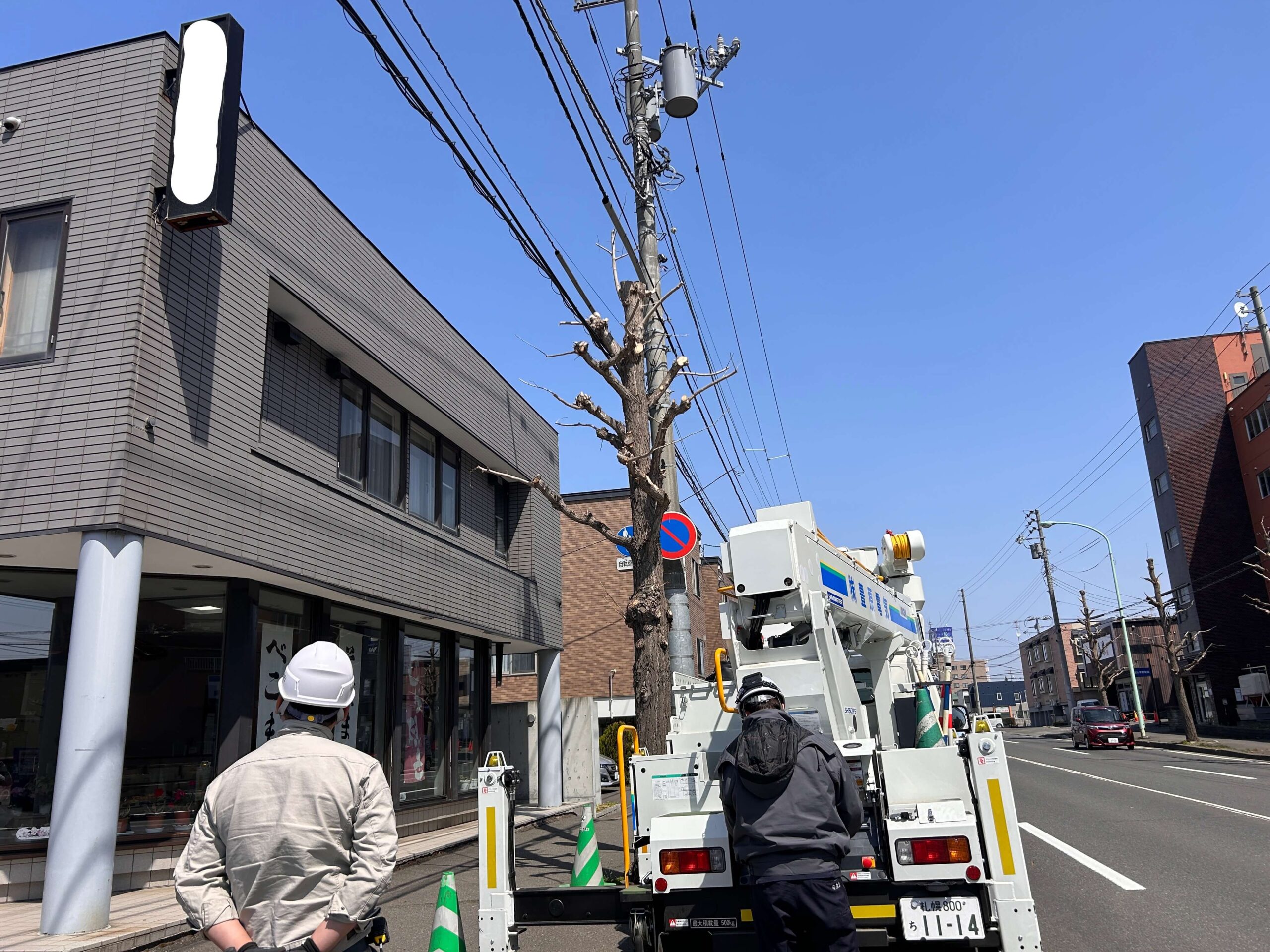 施工開始：高所作業車を現場に搬入し配置。誘導員2名が通行人・車両への安全確認を行いながら作業を開始。
