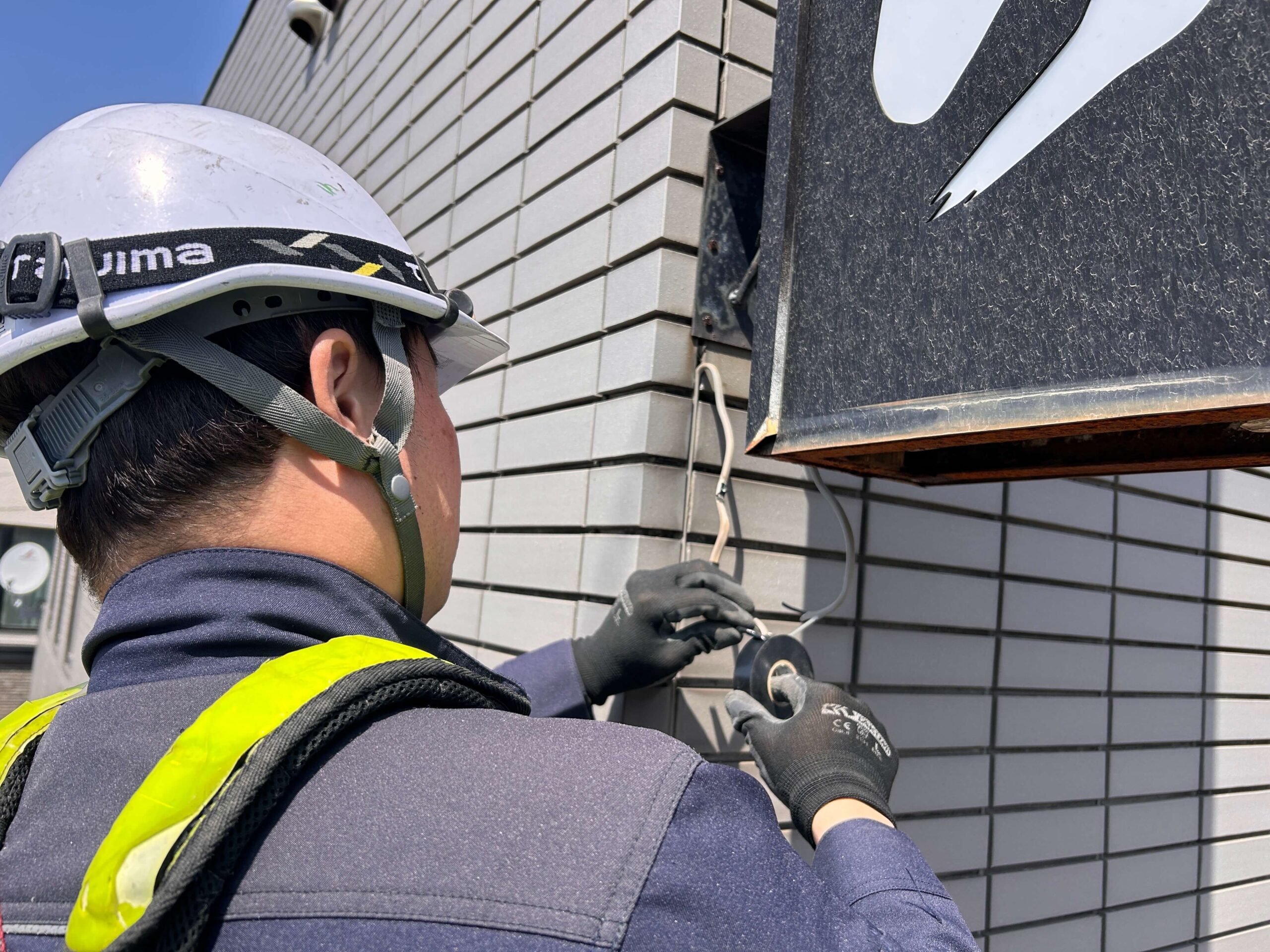 作業中：取付金物のボルト・釘をセーバーソーで切断する作業員。錆が進行した固着ボルトに対応。