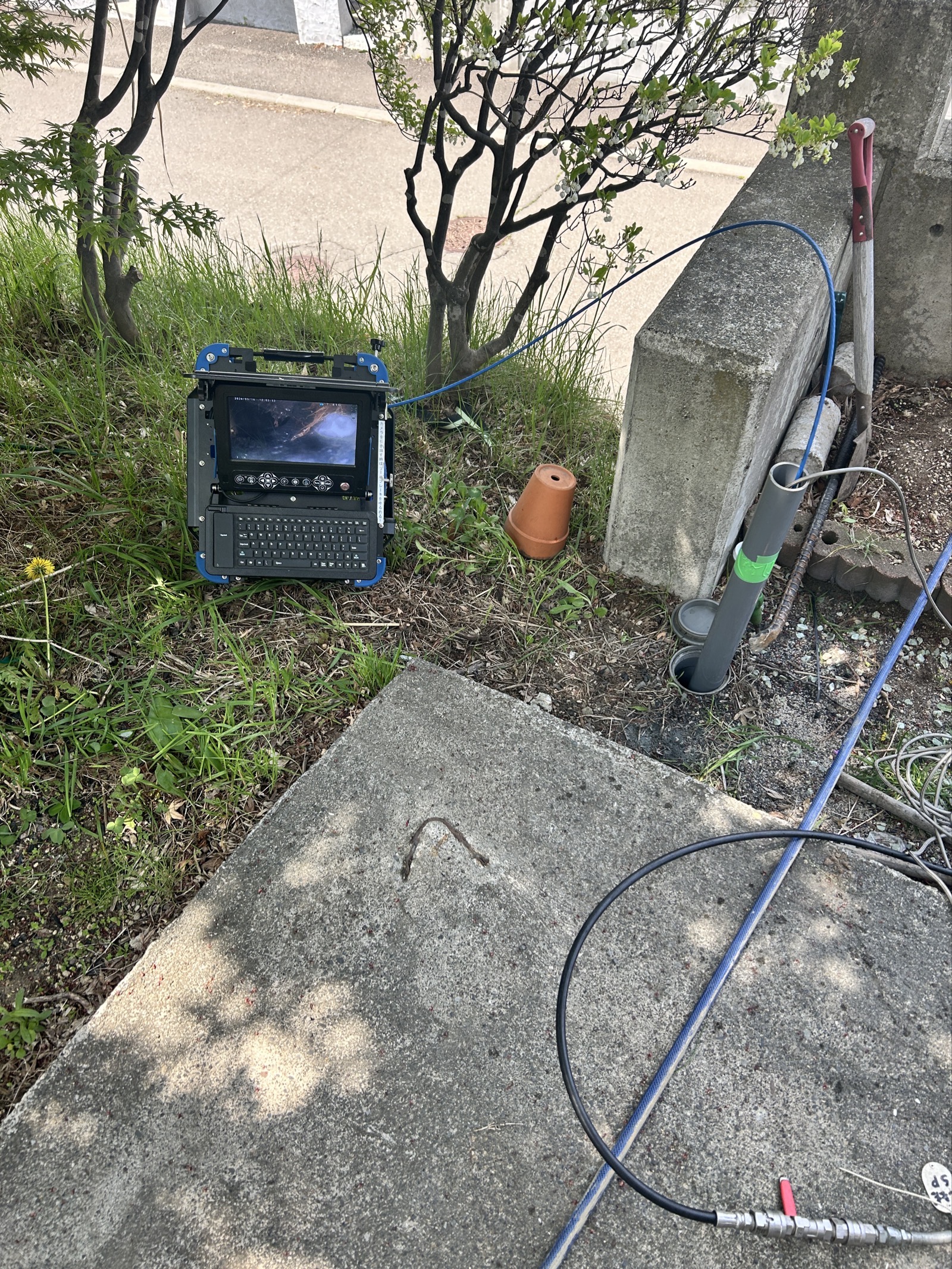 管内カメラと調査機器をセット。桝を掘り起こして経路を確認しながら、カメラを挿入する準備を進めた