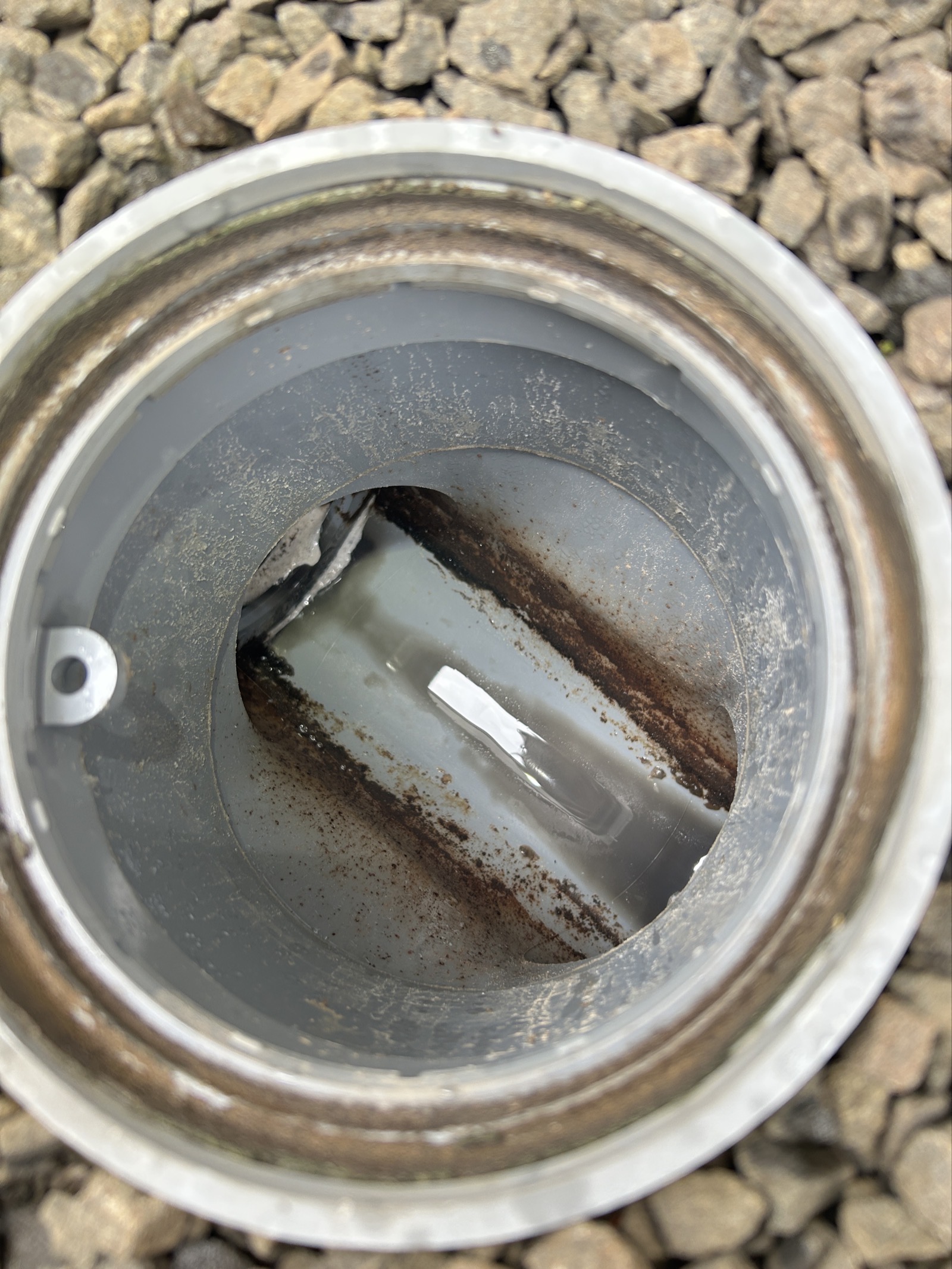 屋外排水桝の施工前の状態。錆と汚れが確認でき、管内の流れが低下していることが見てとれる