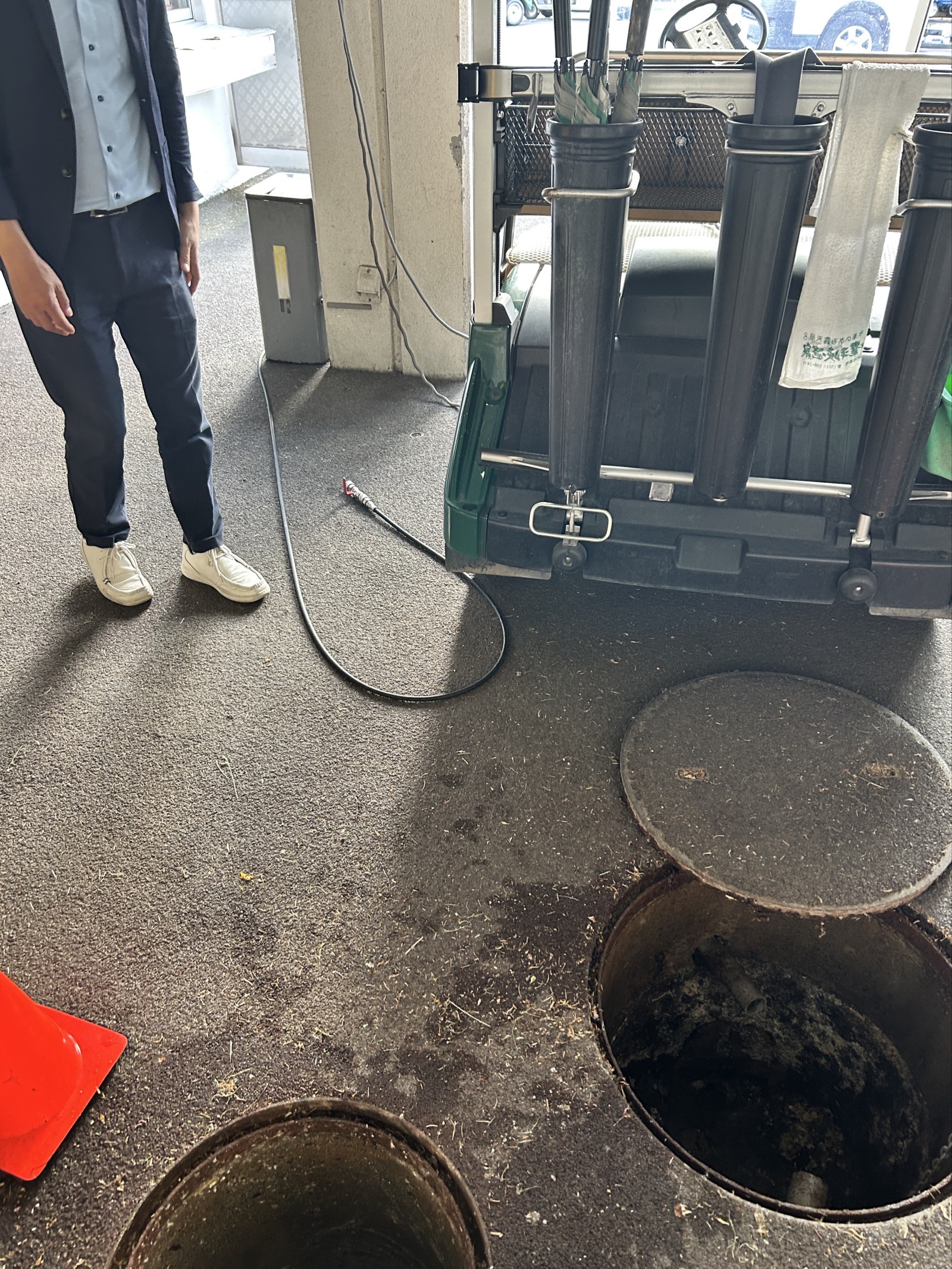 現地での準備状況。マンホールを2箇所開口し、高圧洗浄機のホースを配管内に送り込む段取りを組んでいます。