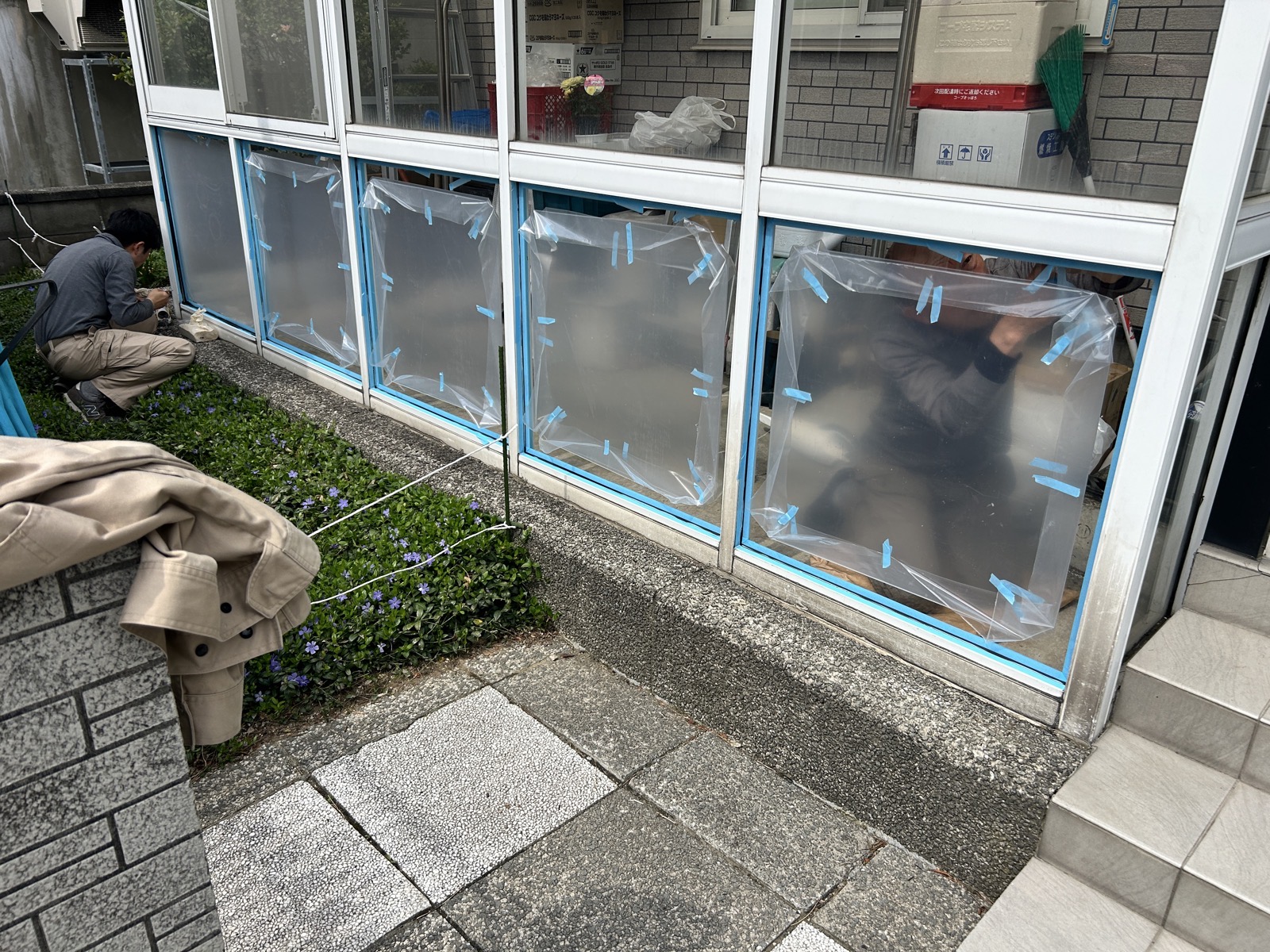 作業中：隣接ガラス面をビニールシートと養生テープで養生した状態