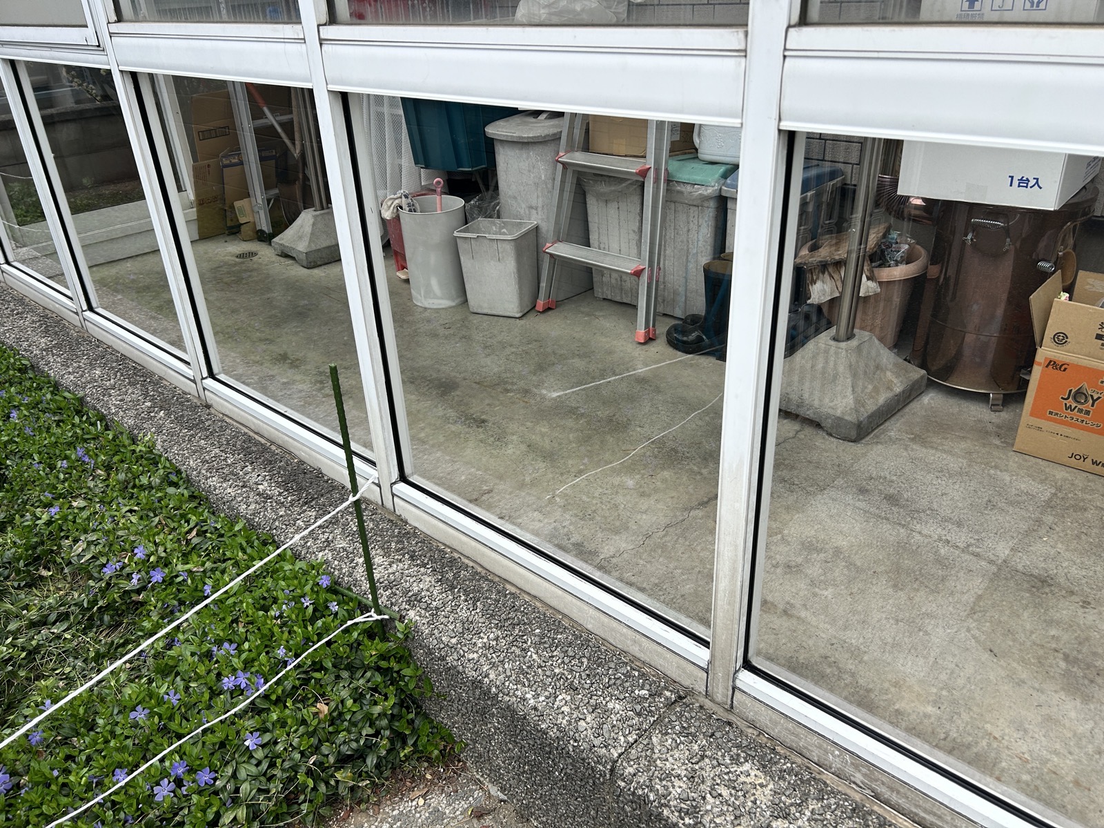 施工後：交換完了した風除室の外観。割れのない透明なポリカーボネートが並ぶ