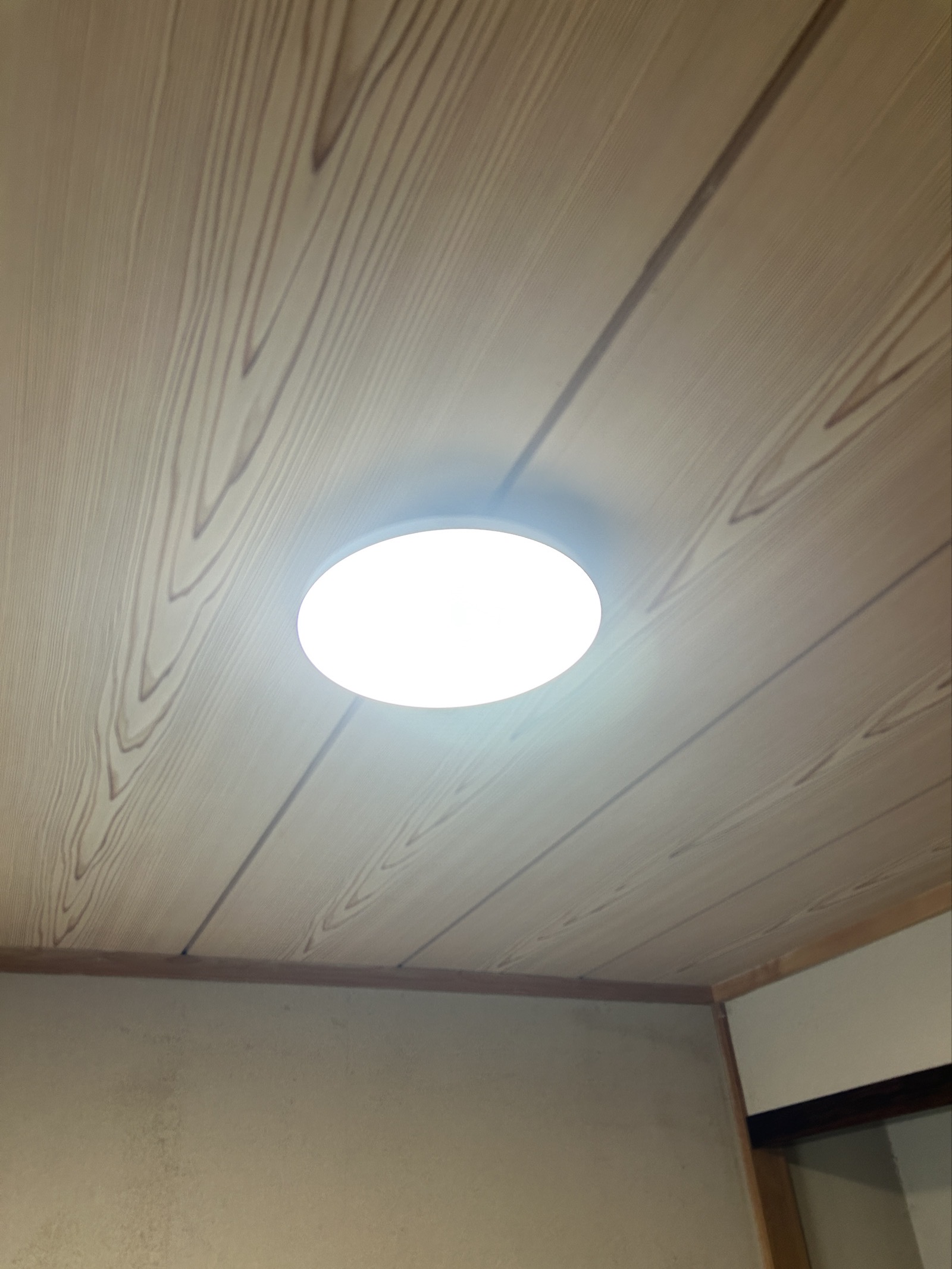木目調天井の和室に設置されたLEDシーリングライト。点灯確認・音声操作テストまで行って引き渡し。
