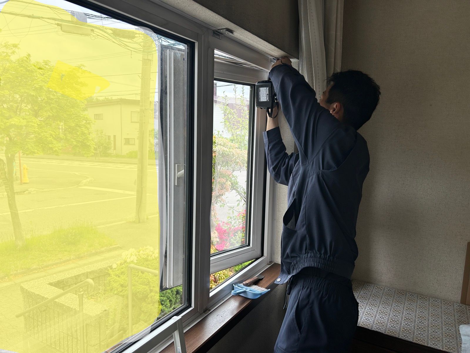 スライド網戸本体をレールに取り付け、高さを微調整している様子（作業中2）