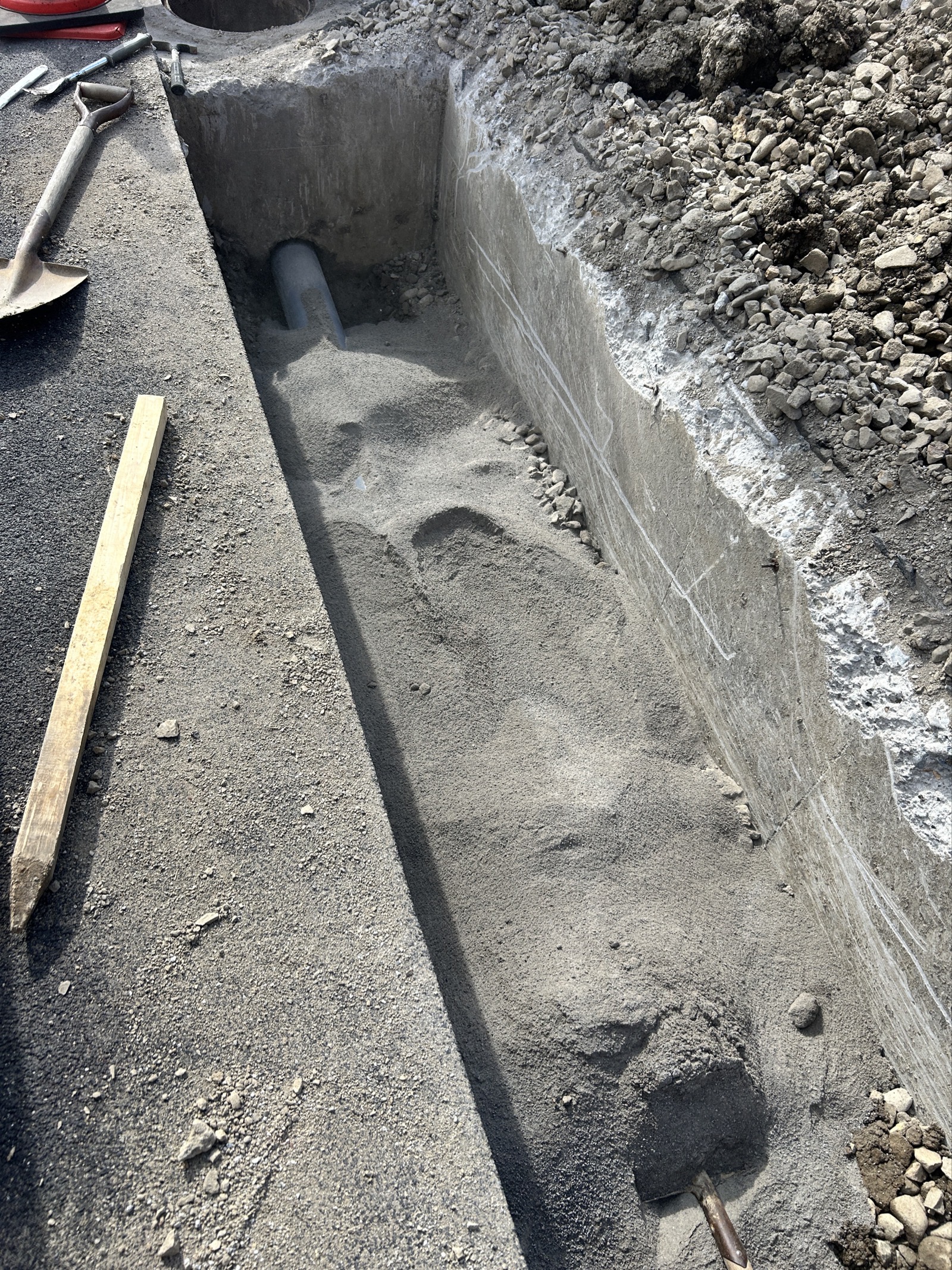 砂巻き立て・層状埋め戻しが進んだ段階——新管が砂で保護され路盤が整えられている