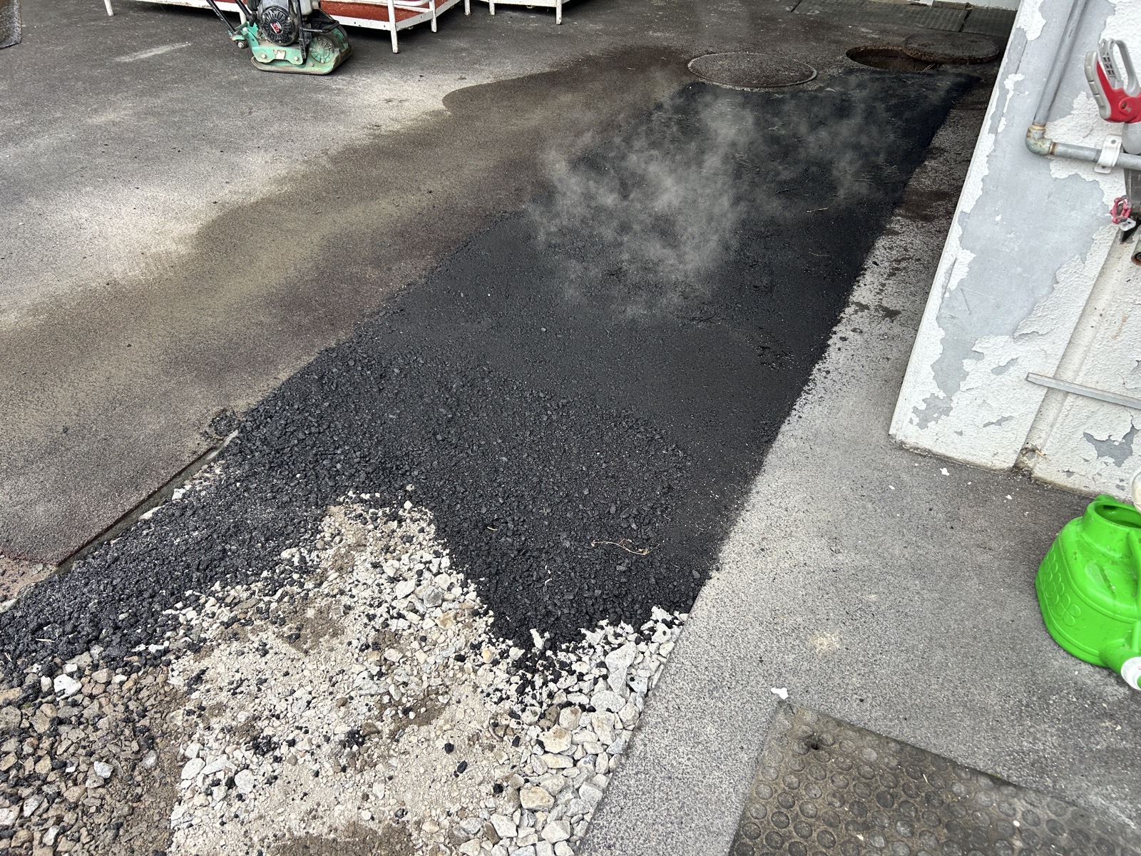 敷均し直後の合材から湯気が上がる状態。転圧前の適正温度を保った加熱アスファルト合材