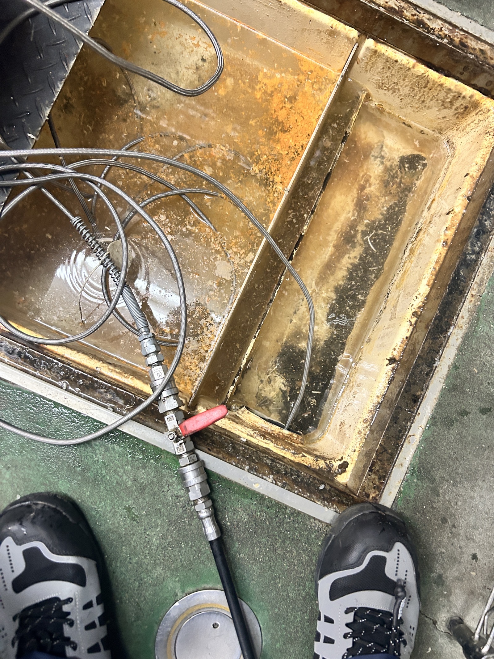 複数マスを使い分けながら管内を洗浄中。油脂混じりの汚水がマス内に滞留している