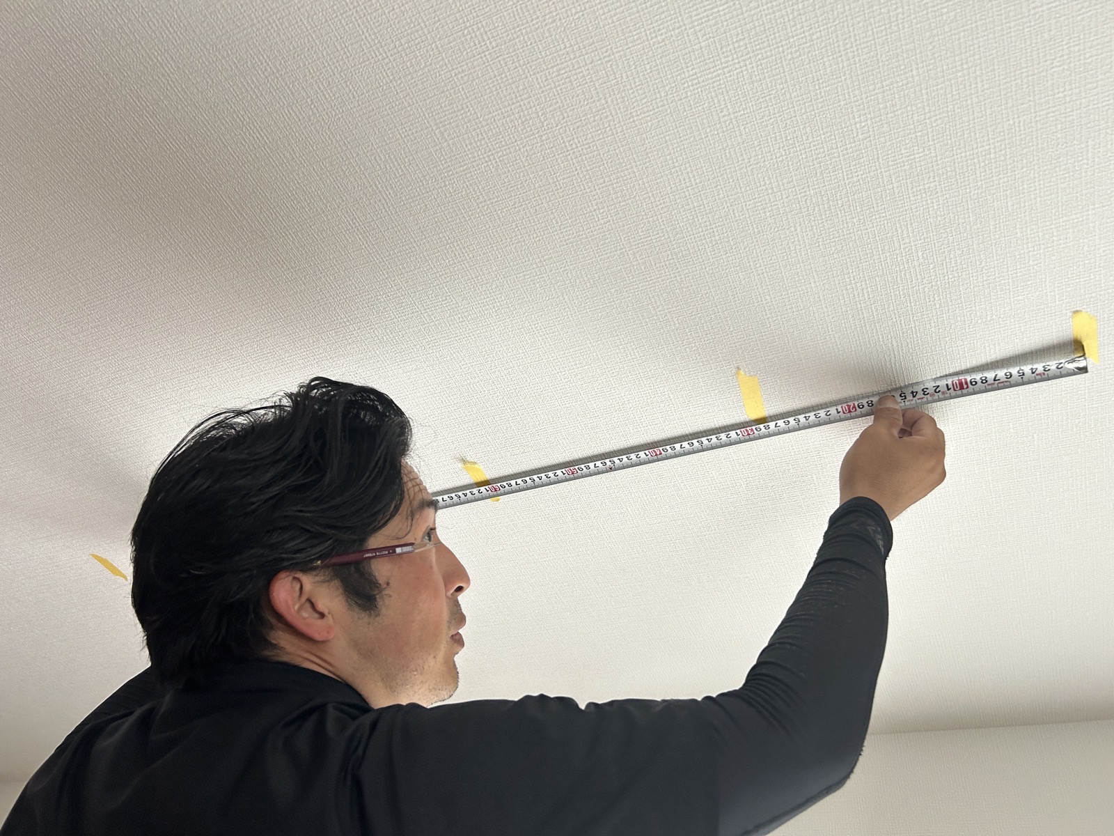 居室天井へのユニット取付作業中。マキタドライバーでビスを固定している