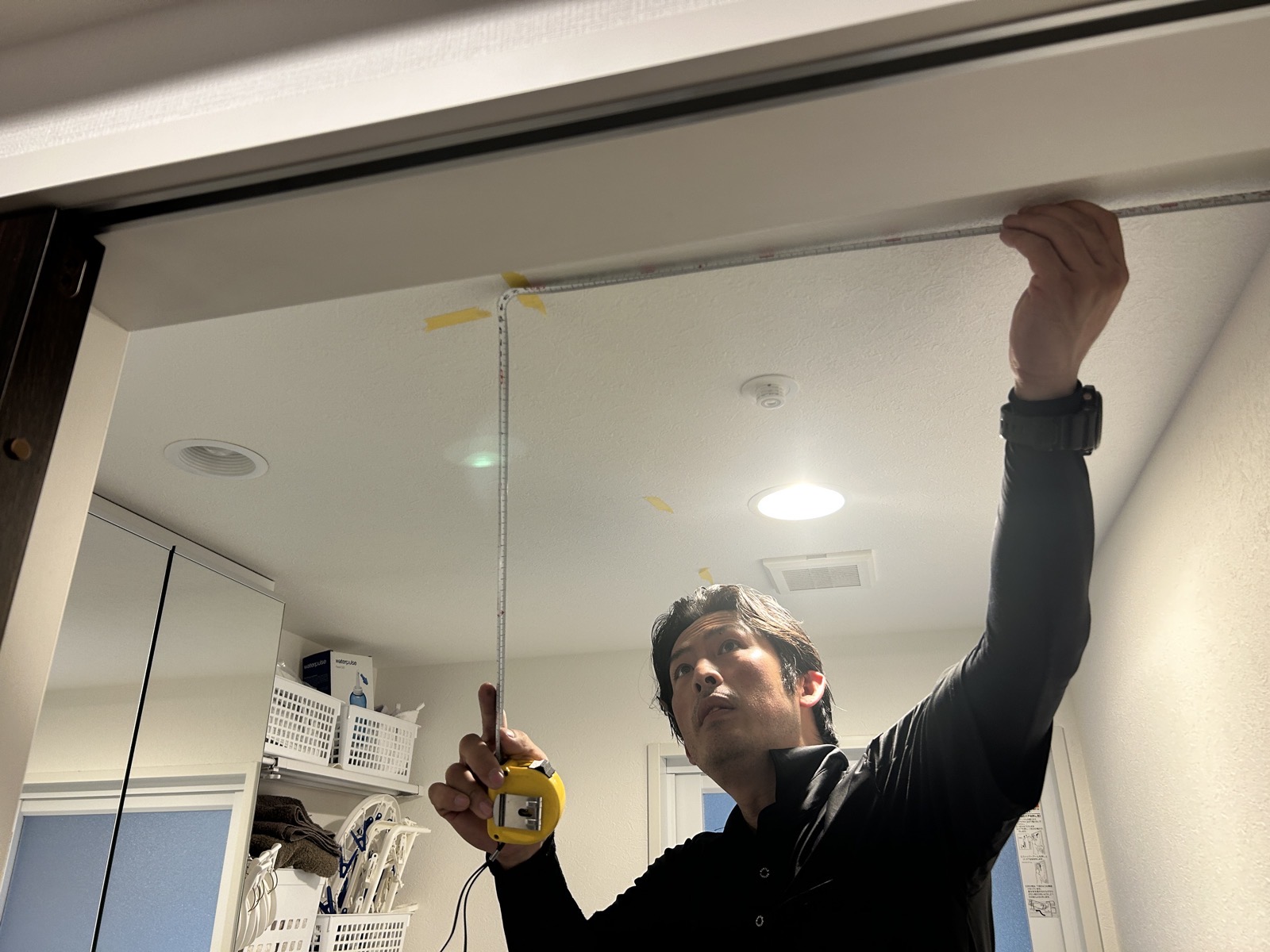 洗面脱衣室の天井高さをスケールで実測。竿を降ろしたときに動線を妨げない位置を確認