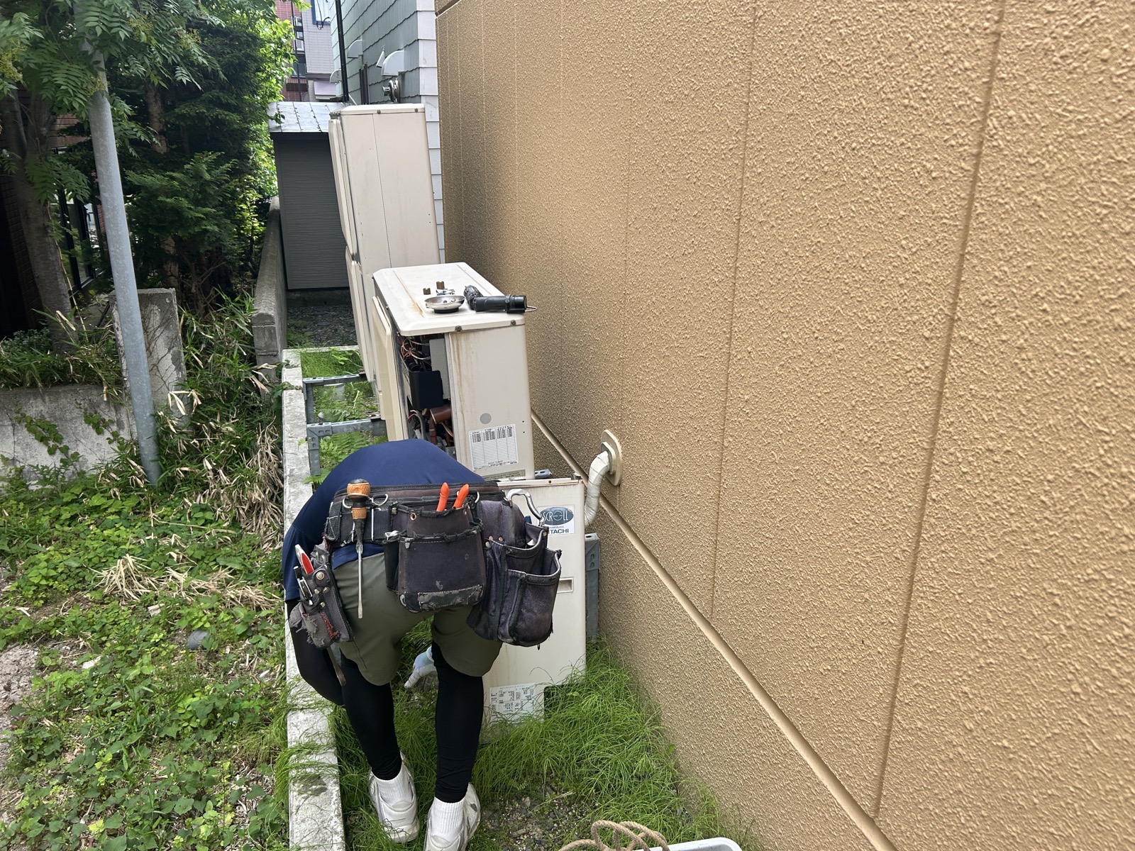 配管切り離しと架台からの取り外し作業。狭い建物裏手でのアクセスが難しい状況での対応