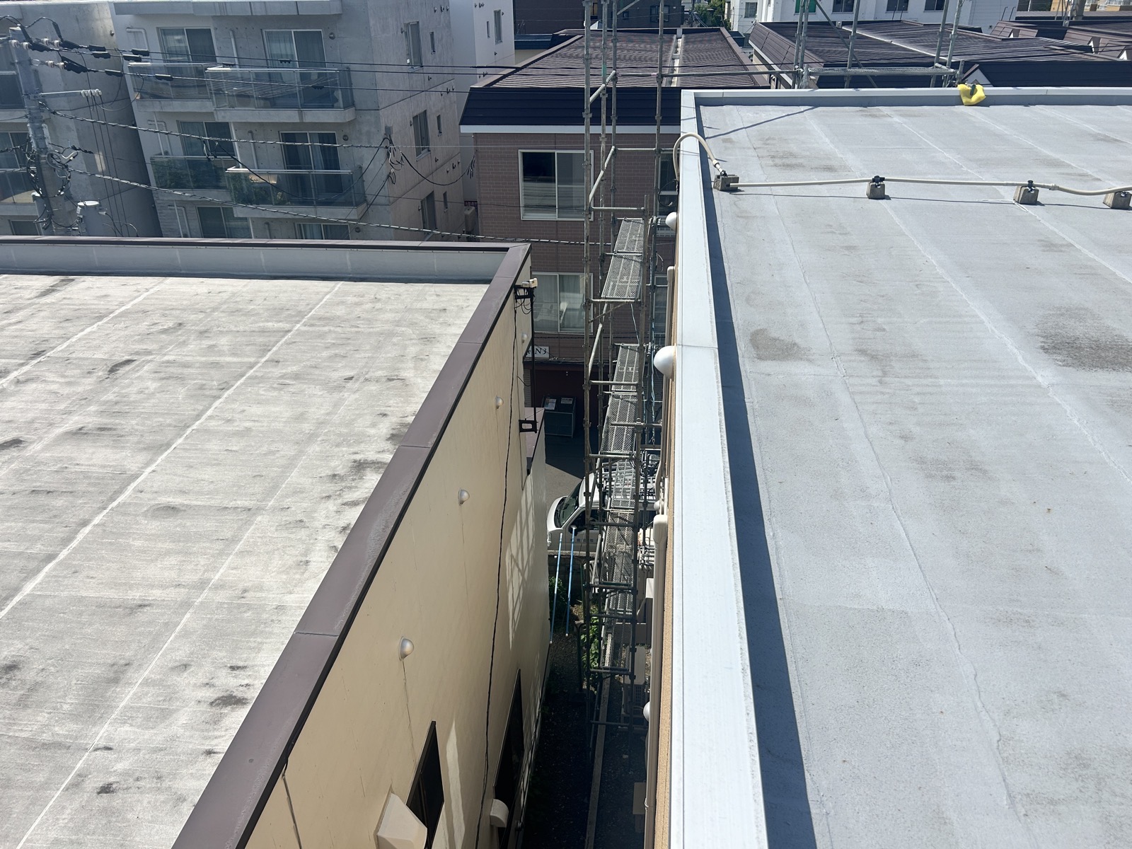 雪庇防止ヒーター設置前の3階建てビル屋上笠木の全景。アルミ笠木が外周を一周している