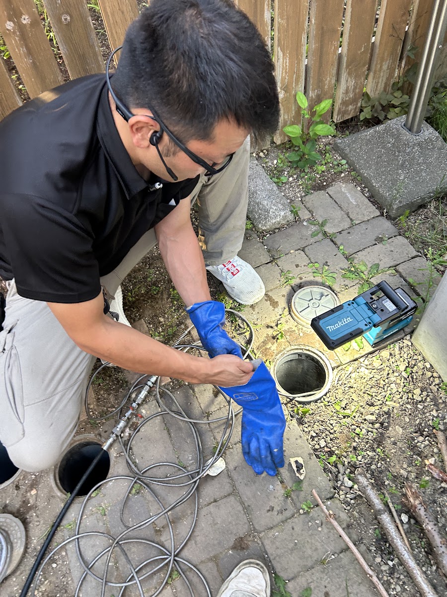 札幌市南区のキッチン 水漏れ現場、屋外の排水桝でカメラ調査の準備をする様子