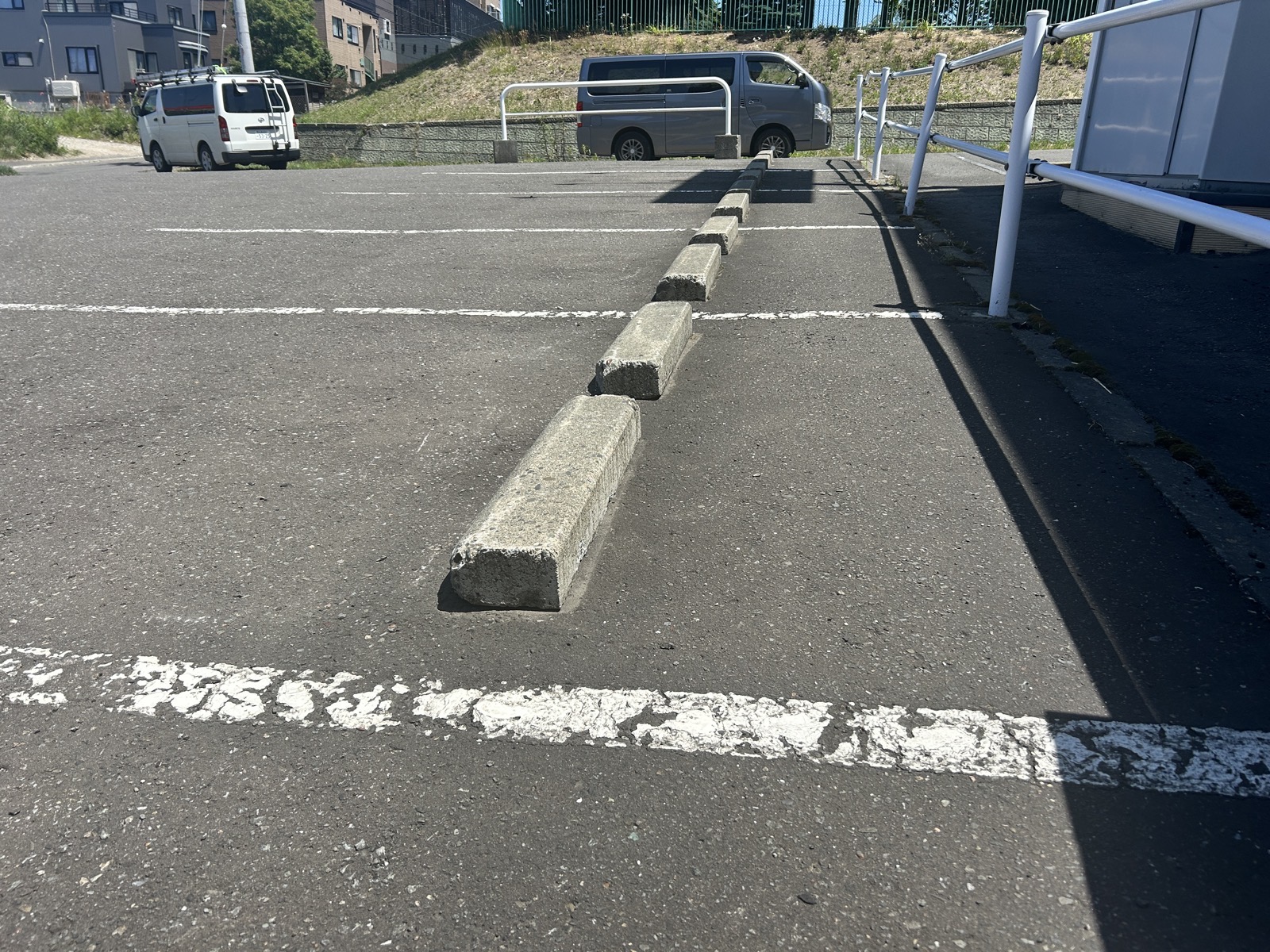 駐車場奥側の通路沿いに再設置された車止め。糸に沿って直線的に並んでいる