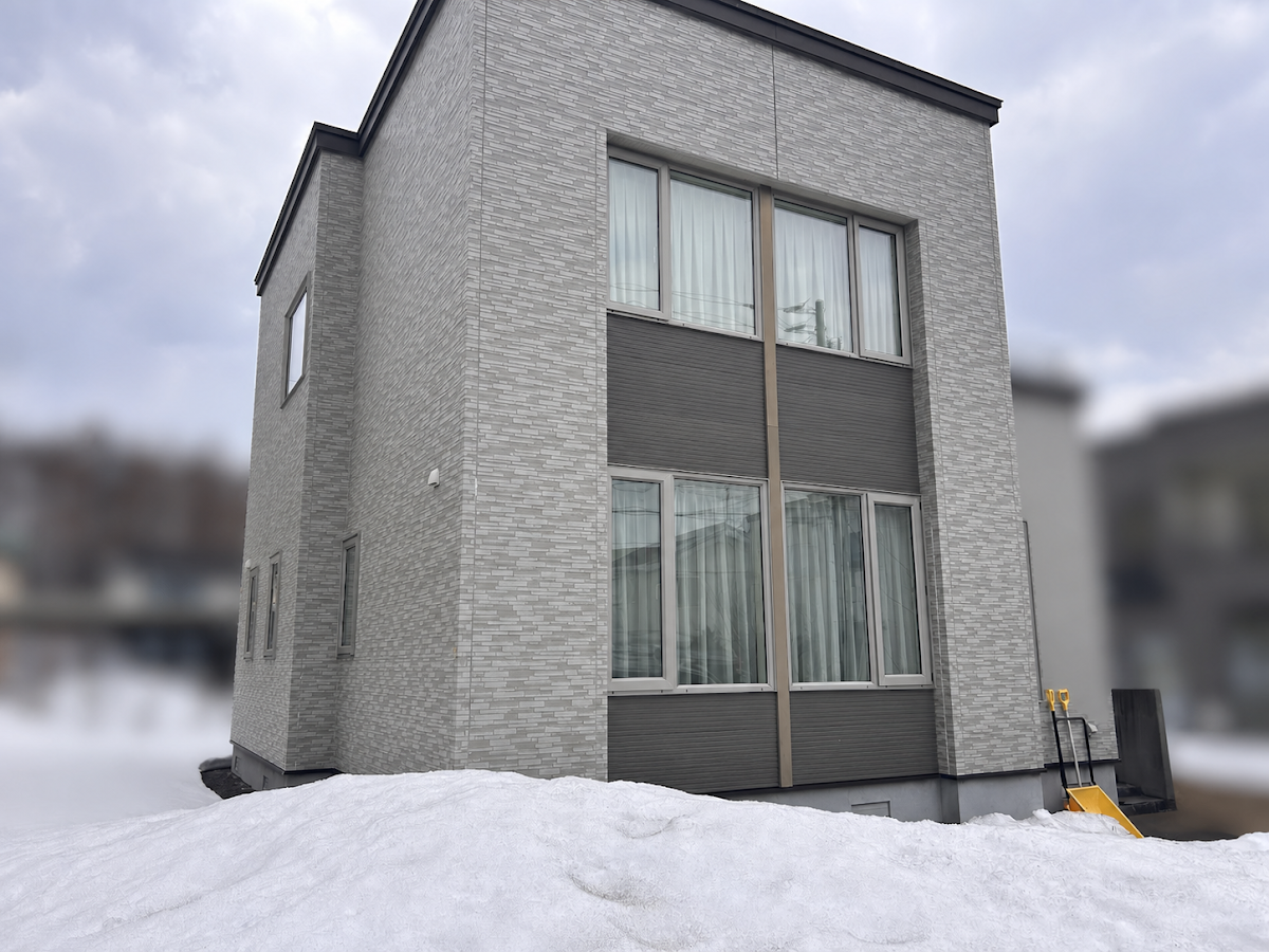 札幌市清田区、外壁塗装前の築25年住宅の外観(積雪期)