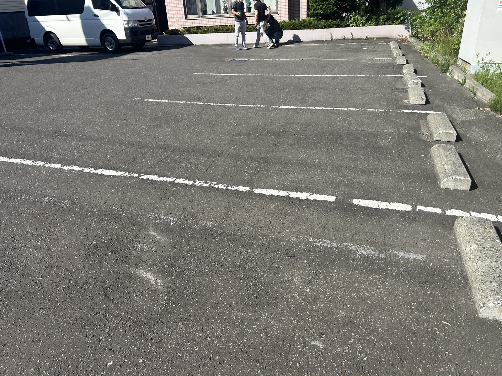 清田区の商業施設駐車場の全景。奥に見える車止めの列にずれや歪みが見られる