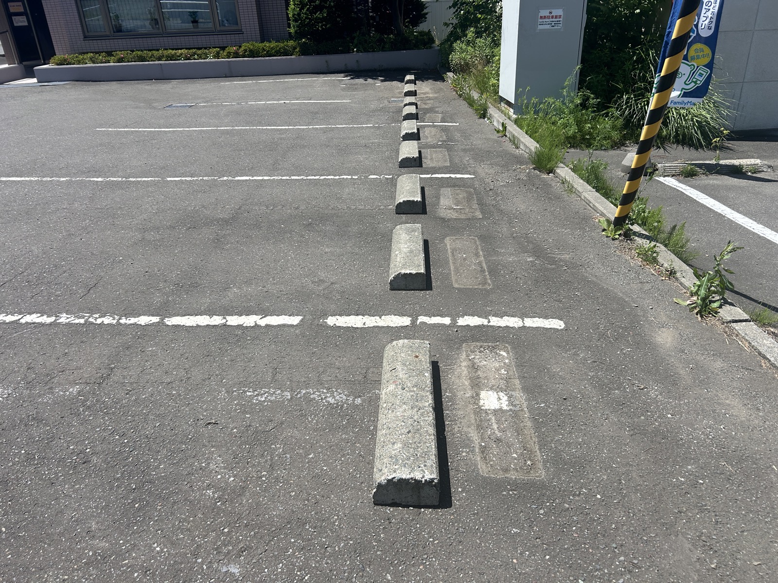 修繕後、まっすぐ一列に並んだ車止め。ボンドの跡が新しい設置位置を示している