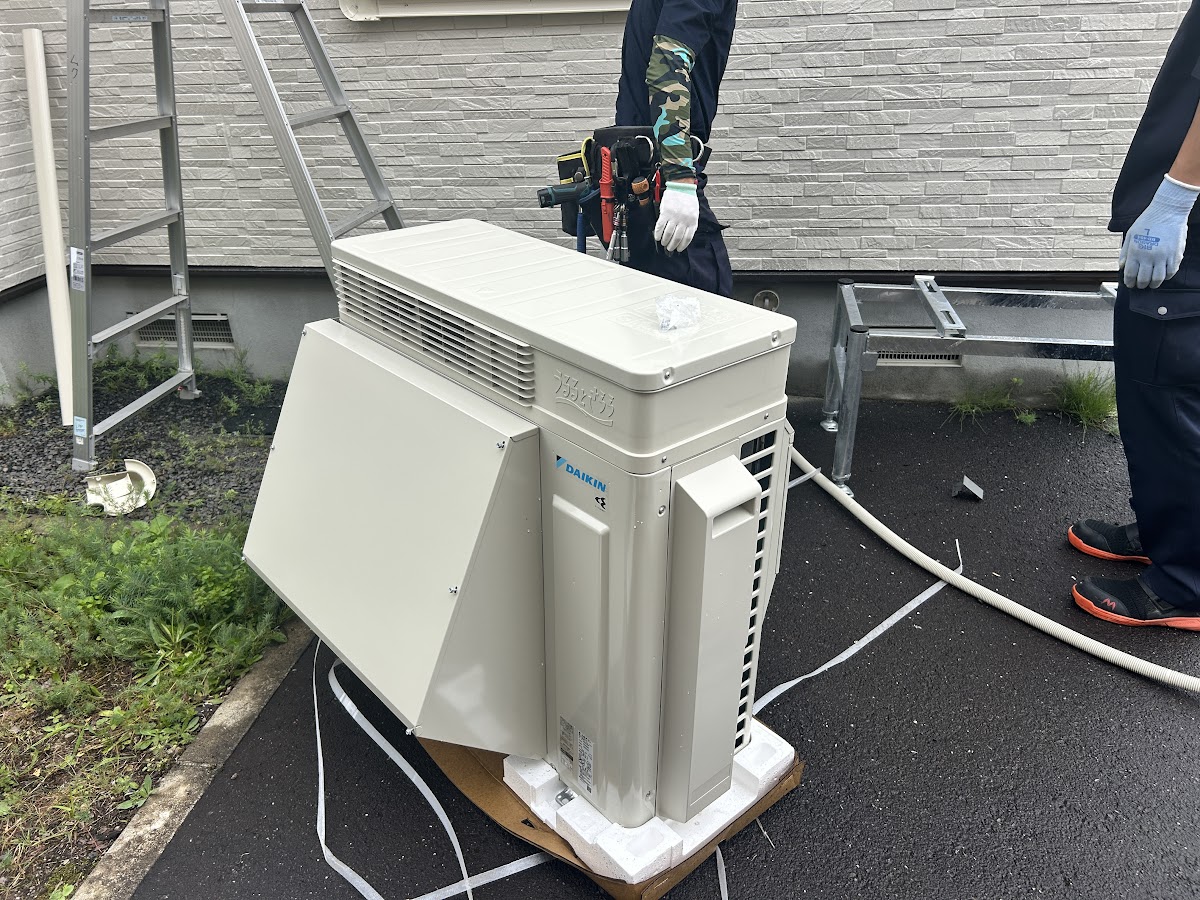 架台に室外機を据え付ける作業をする職人たち