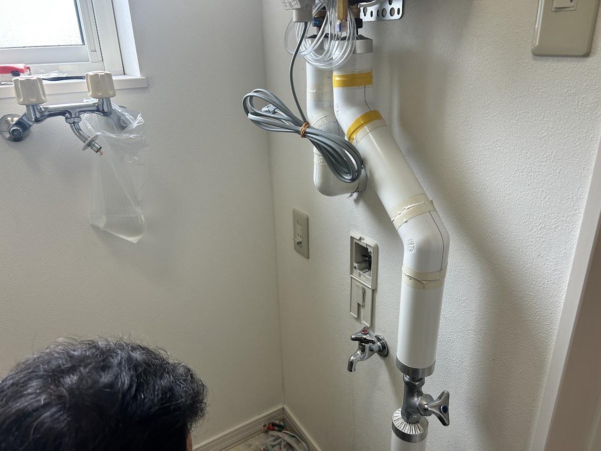 給湯器下部の配管接続部と止水栓の様子
