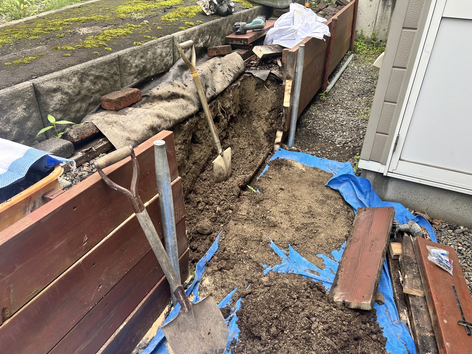 掘削した基礎部分をスコップで整地している様子