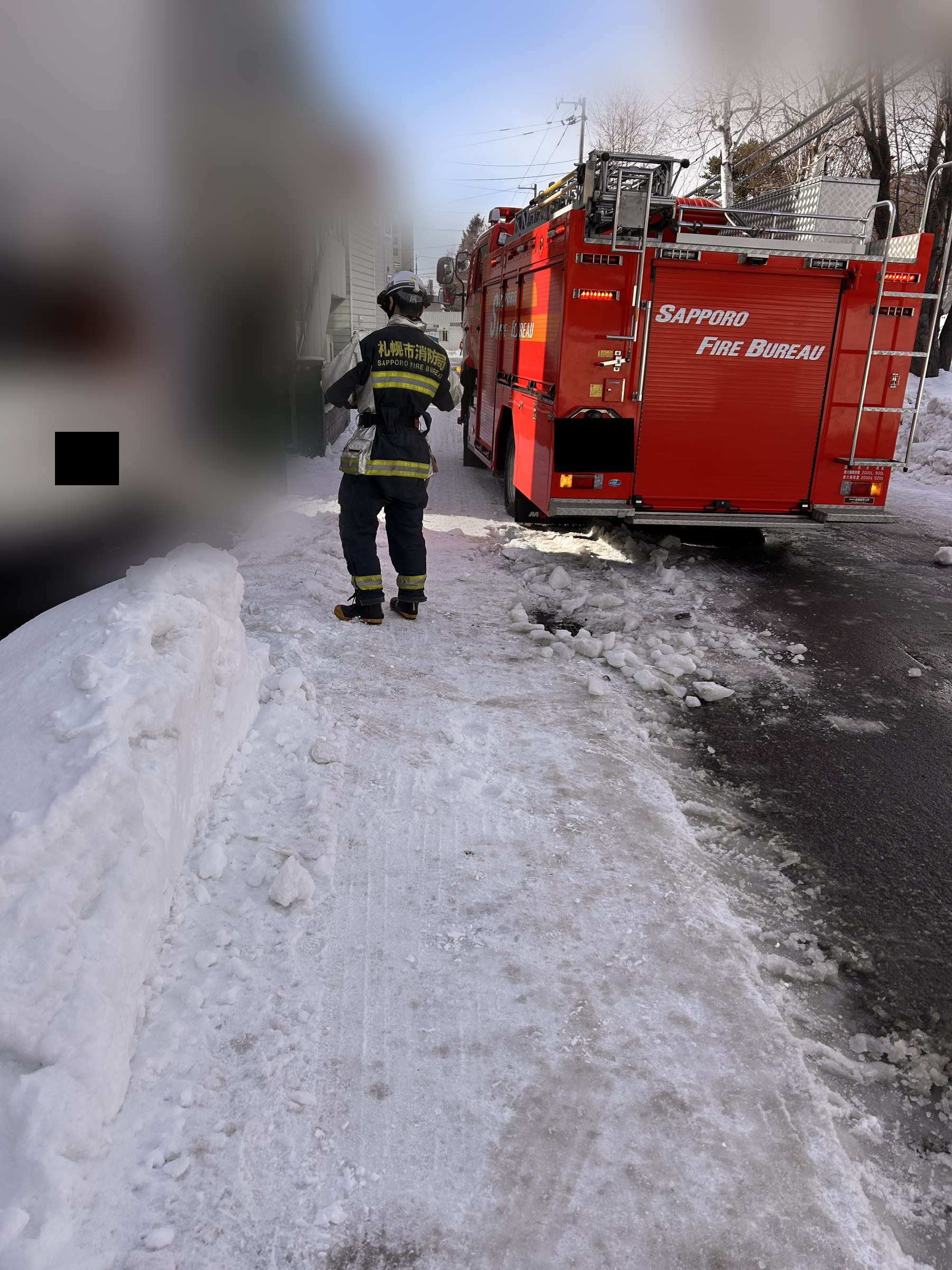 下水管から上がった灯油臭の通報を受け住宅街の路地に到着した消防車と消防隊員
