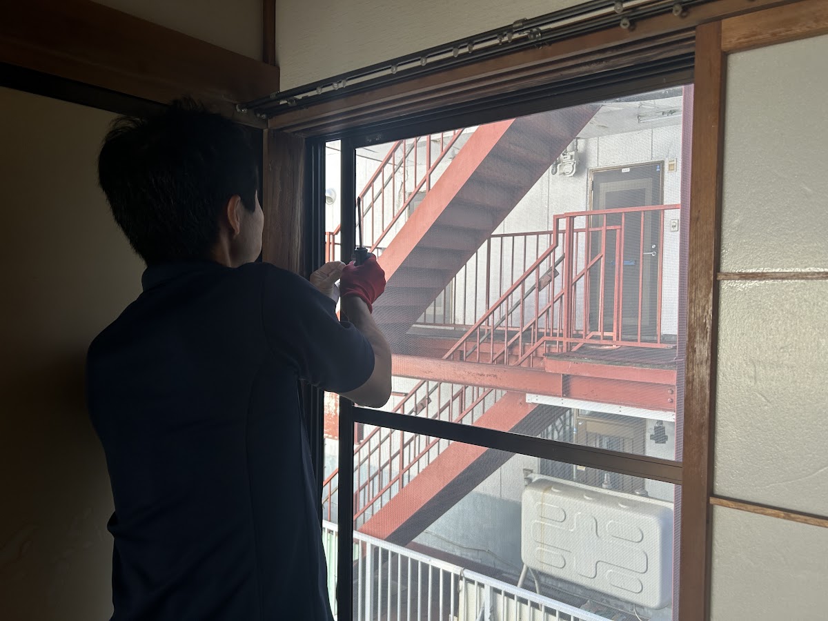 札幌市白石区のアパートで網戸 修理の作業前、レールから網戸を取り外す様子