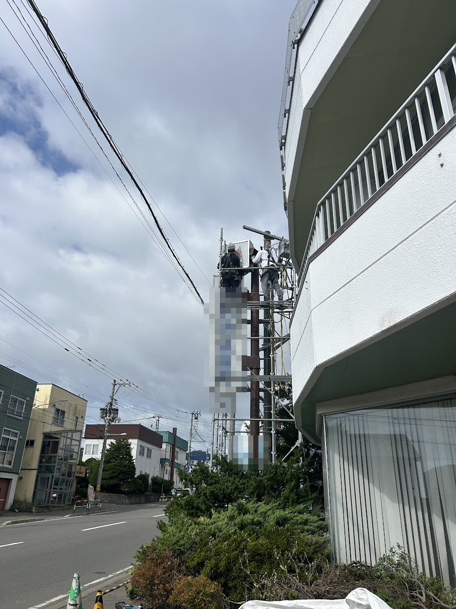 足場の上から看板本体を解体していく作業の様子