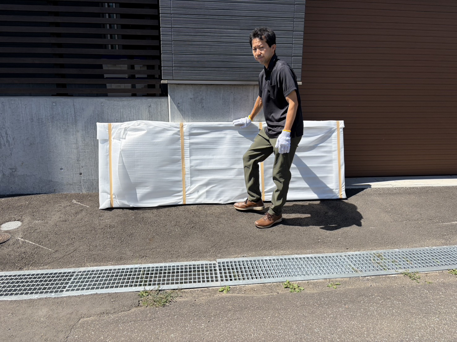 鉄工所で製作した鉄製格子扉を運び入れる様子