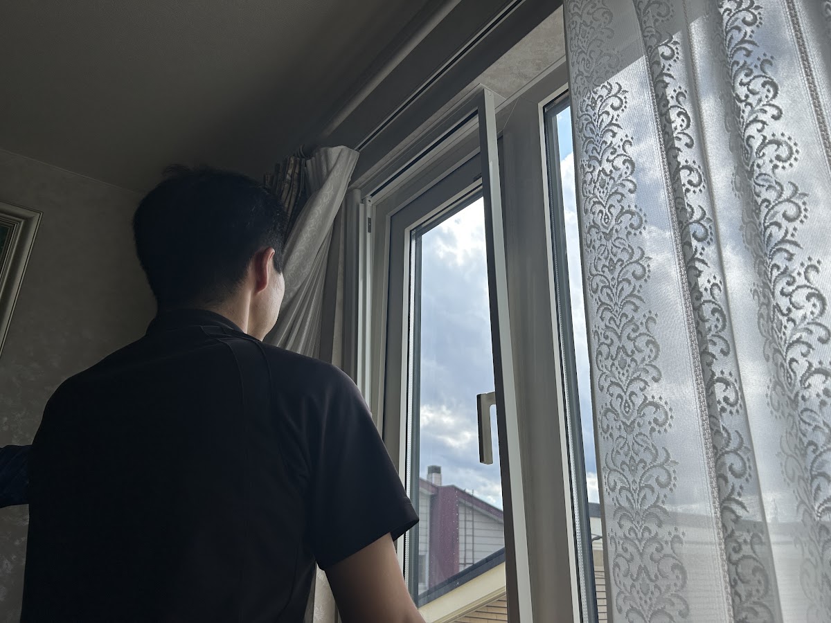 窓を開けて既存のロール網戸のレール部分を確認している様子