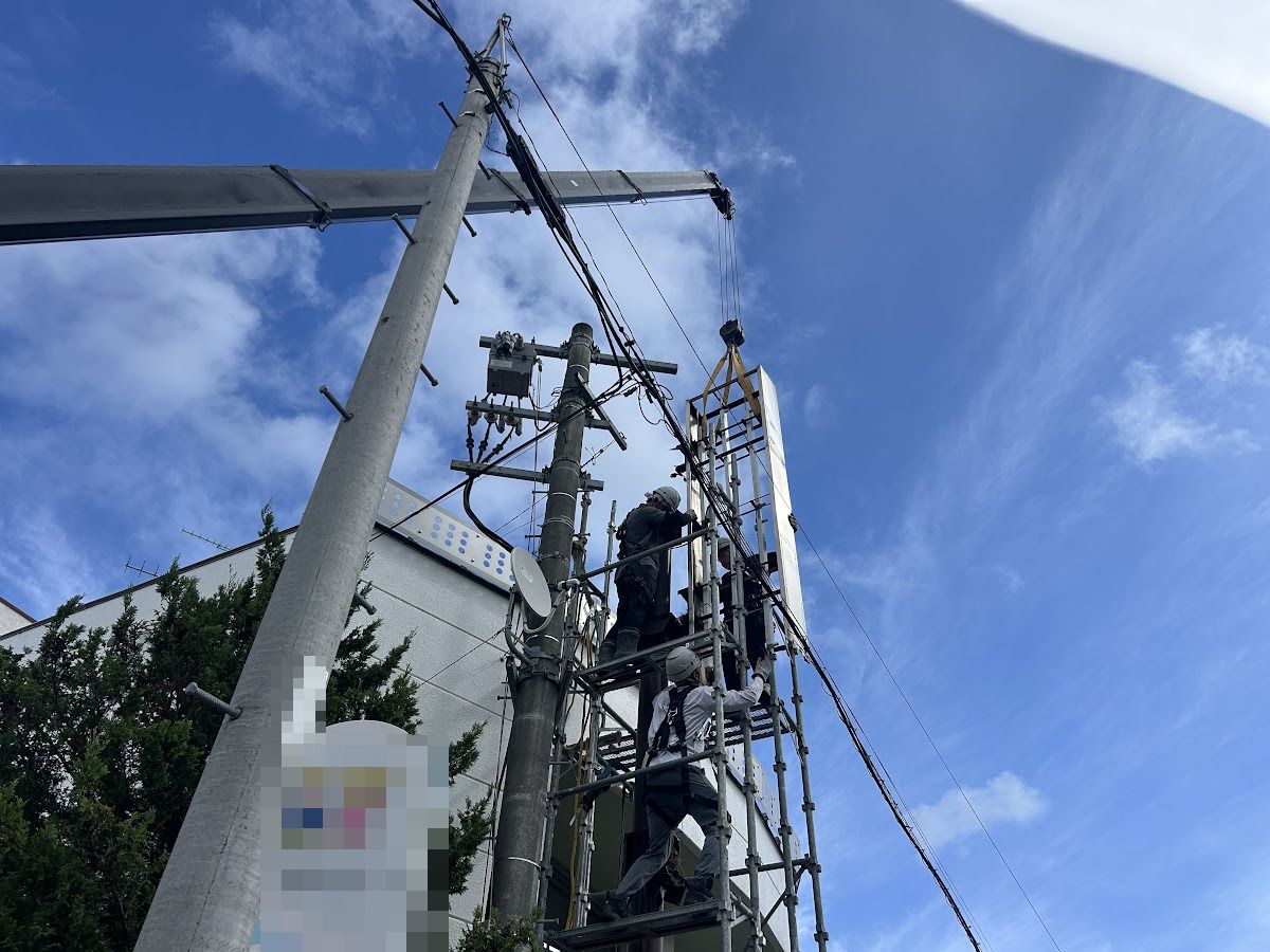 札幌市南区・内科医院の自立看板、クレーンによる看板面の吊り下ろし作業中