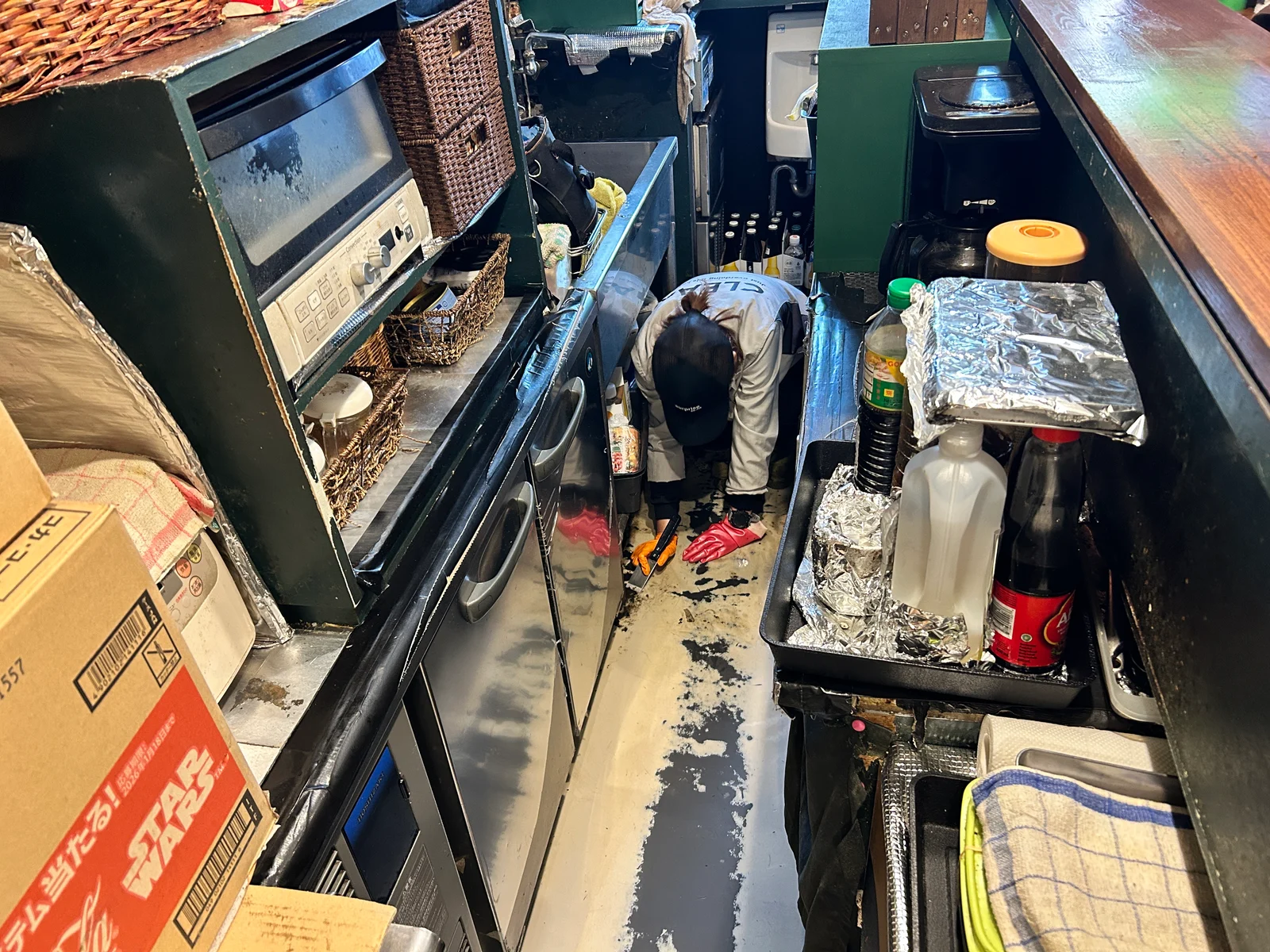 北嶺建設の専門協力会社の代表が、店舗の床で道具を使って作業している様子
