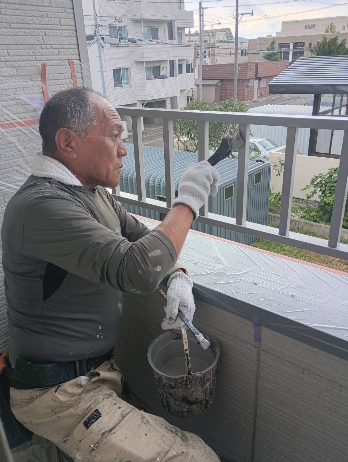 手すり上部を丁寧に塗装している様子