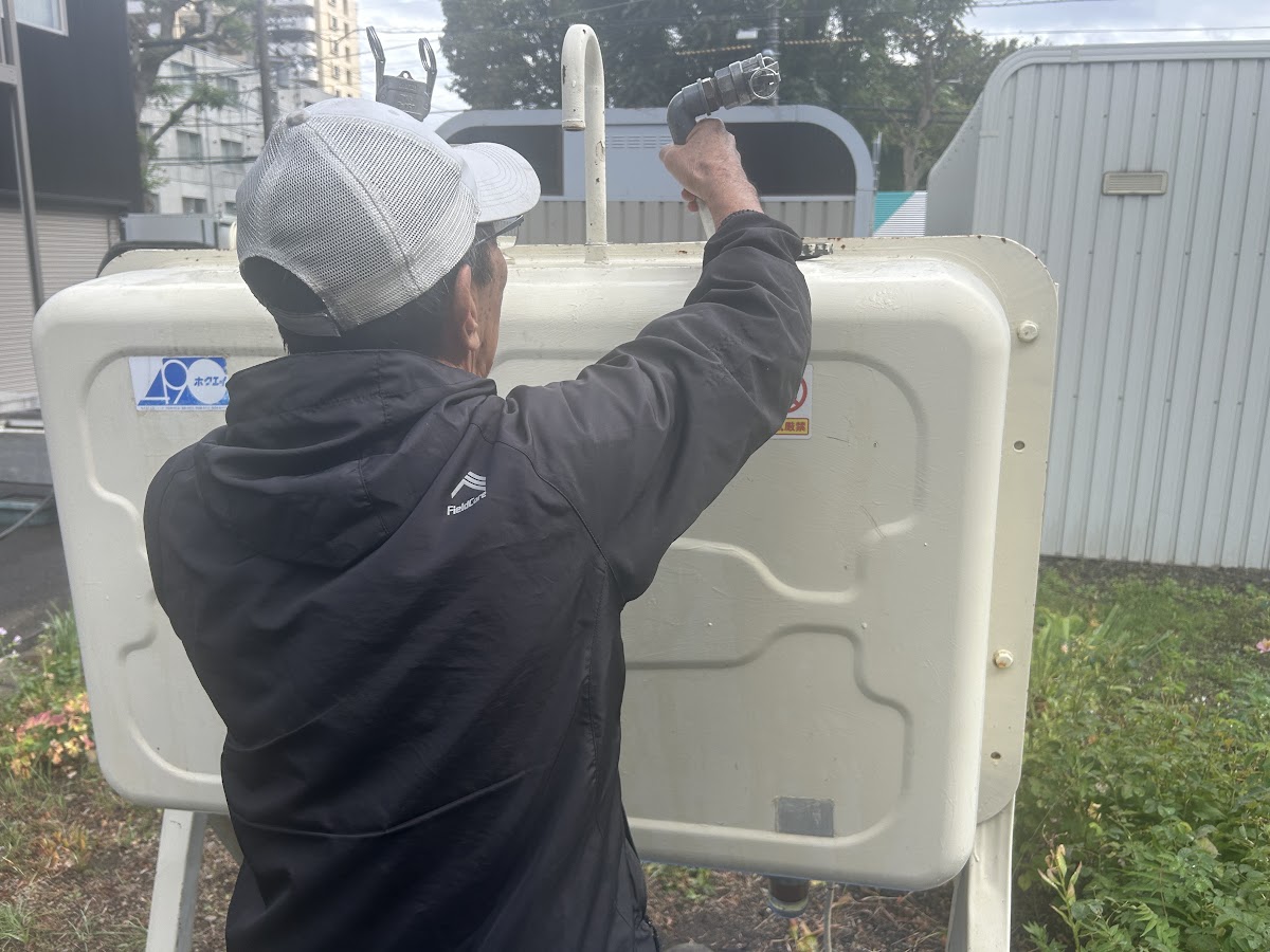 作業員がタンク上部の給油管付近で作業している様子
