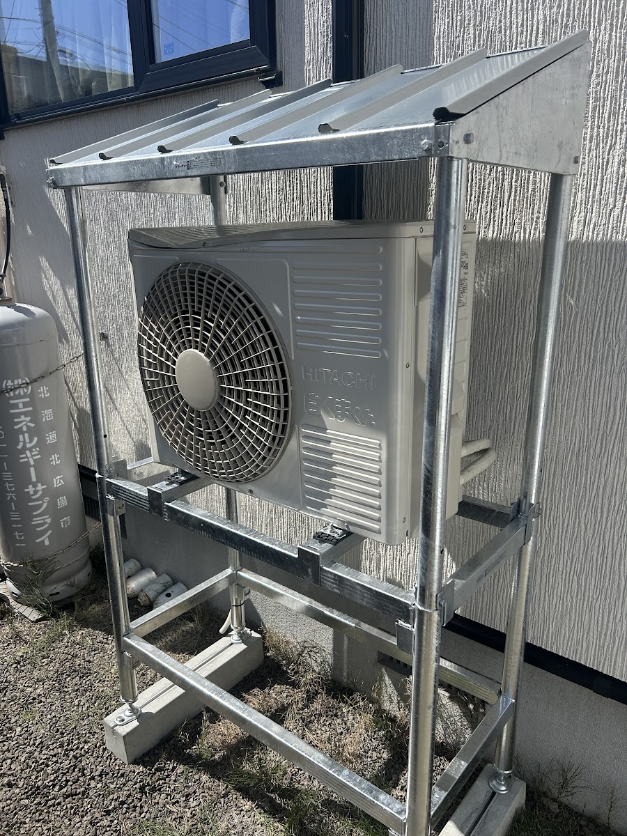 正面から見た交換後の架台。室外機全体が屋根で覆われている