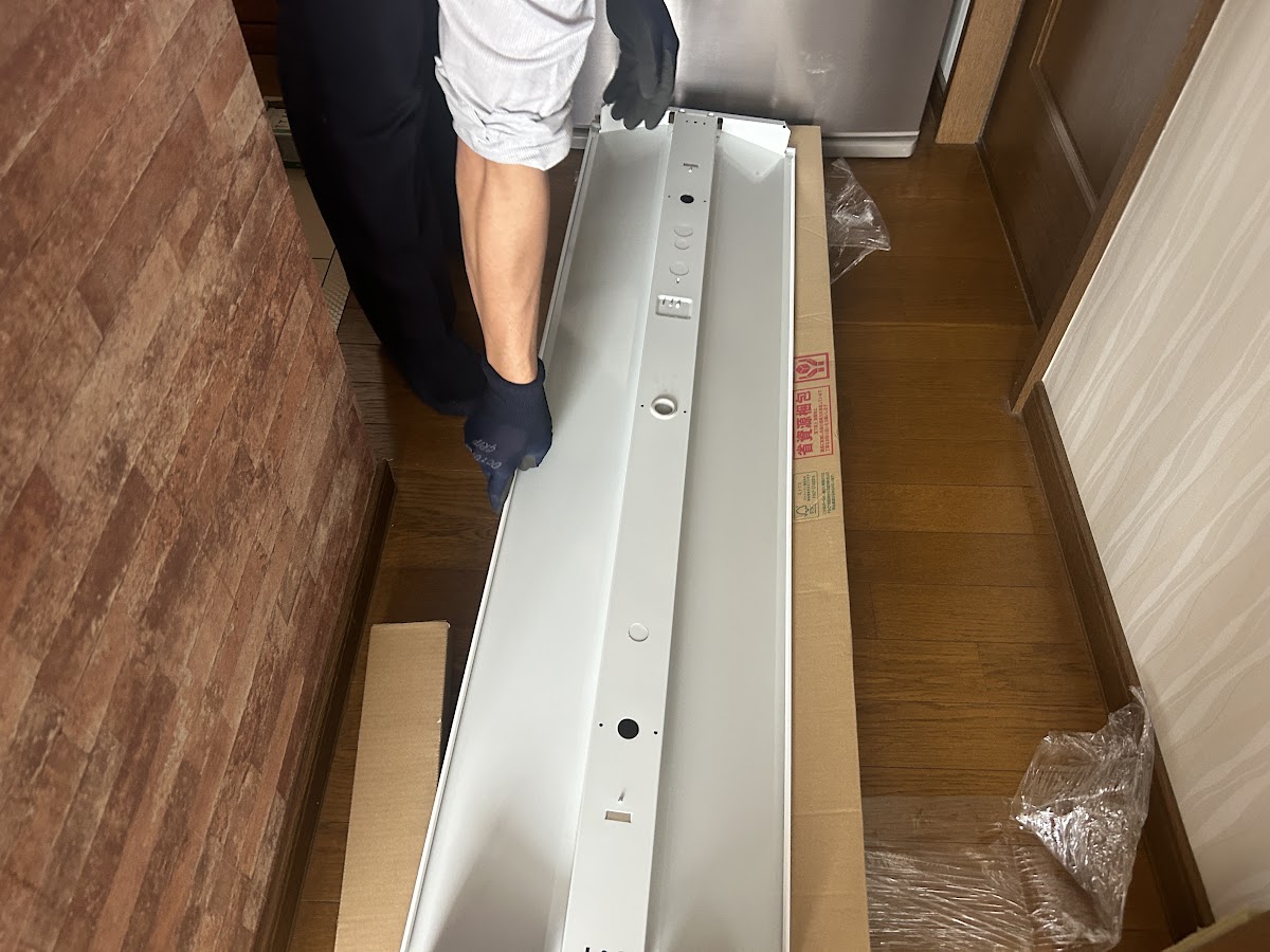 納品されたLED埋込型器具本体を床の上で確認している様子