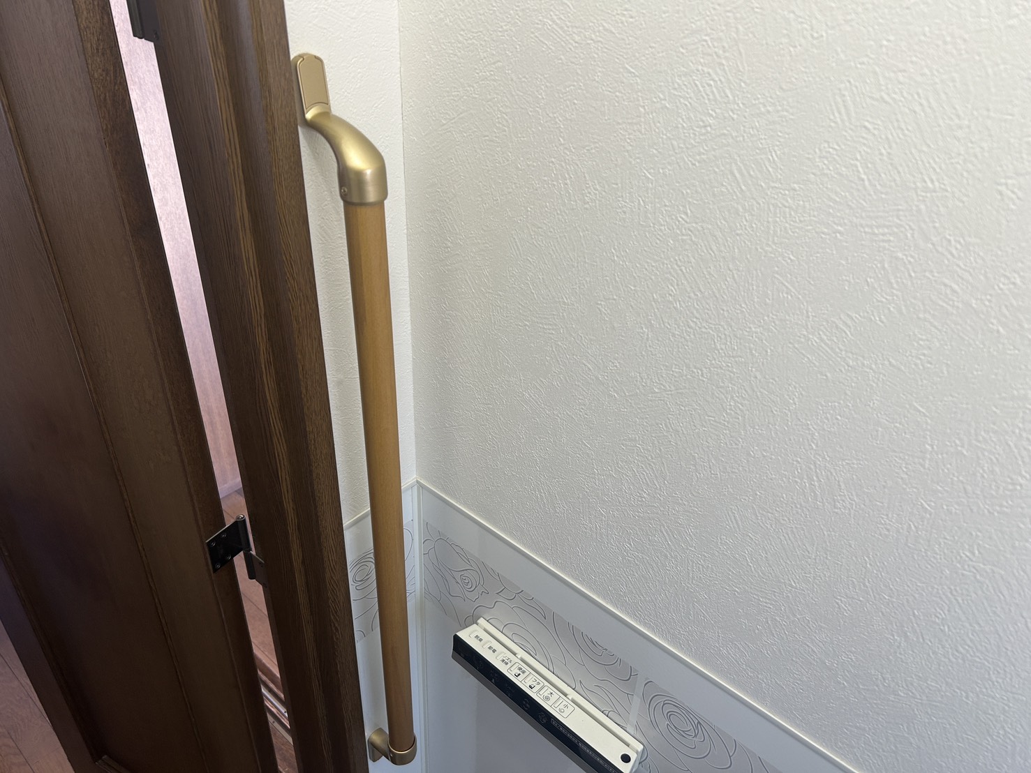 トイレのドア横の壁に縦向きに取り付けた手すり