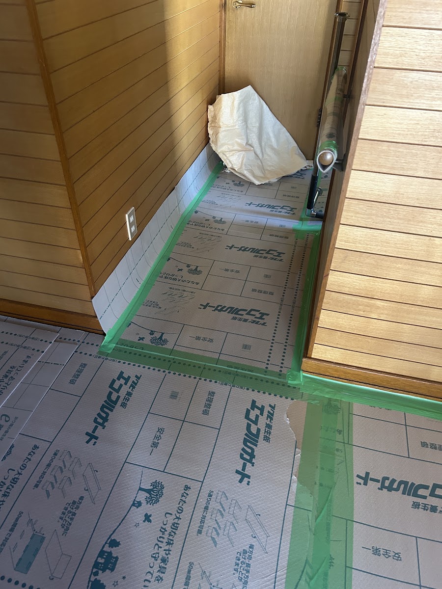 床から壁の下部まで養生した廊下の奥